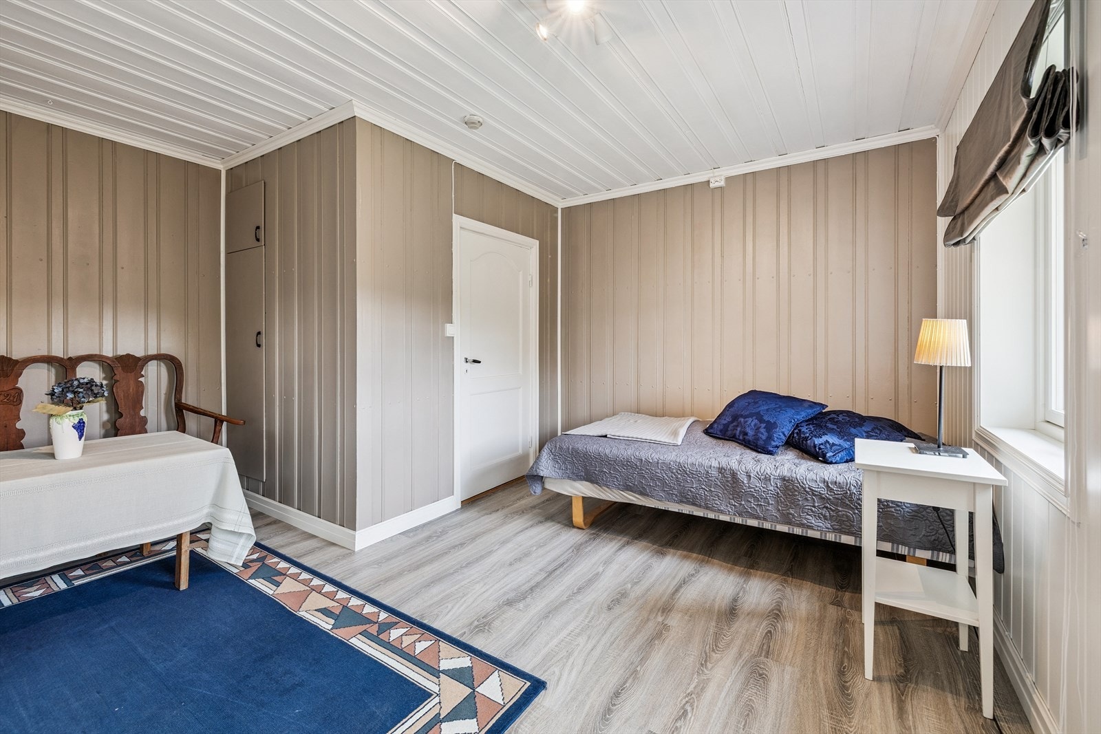 Det andre soverommet i etasjen har lyse overflater og laminat på gulvet. Galleribilde