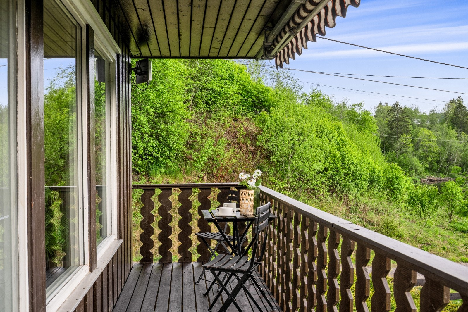 Balkongen har gulv belagt med terrassebord og plass til en sittegruppe. Galleribilde