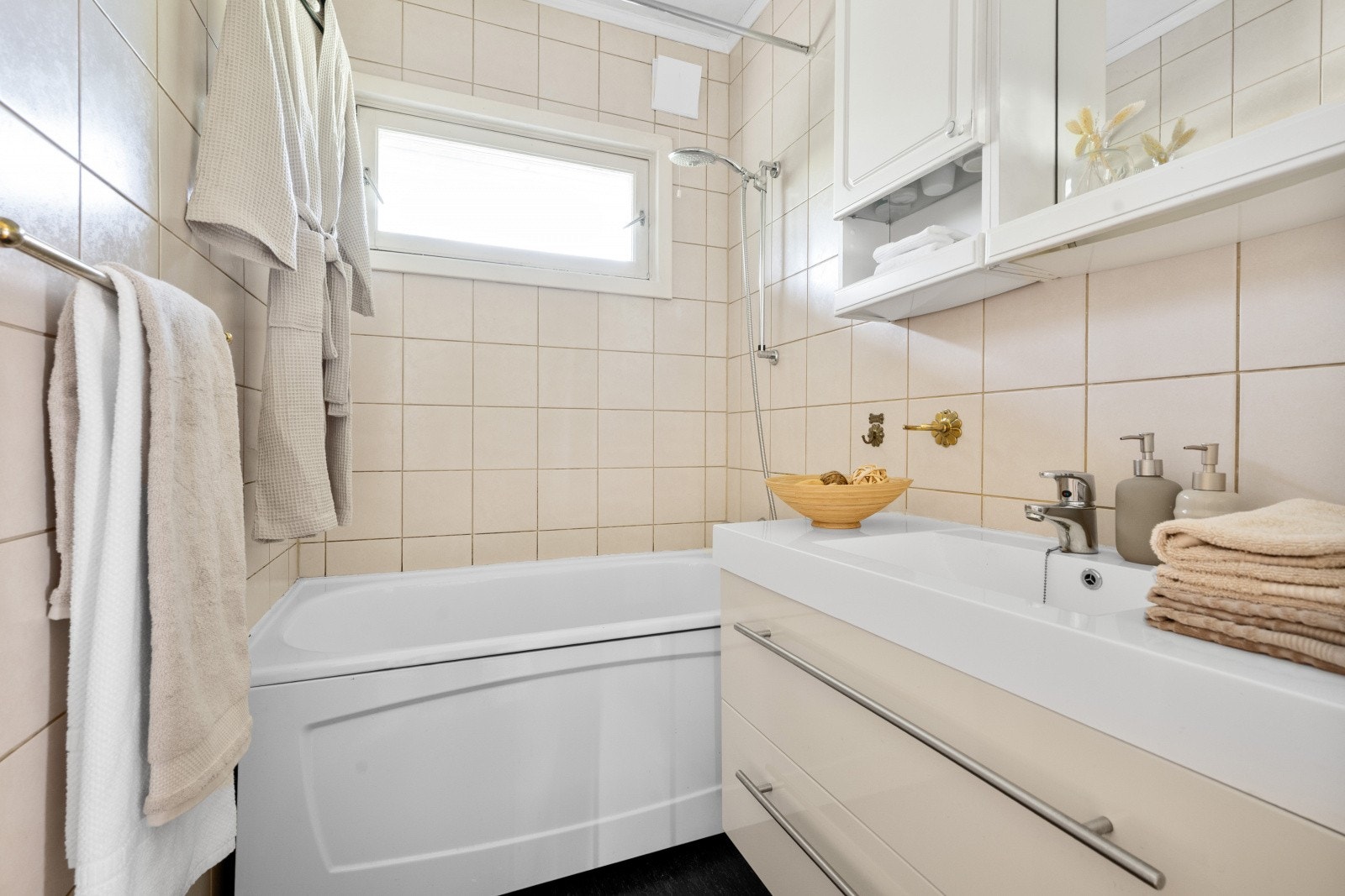 Badet i første etasje er utstyrt med badekar, servant med underskap og overskap. Galleribilde