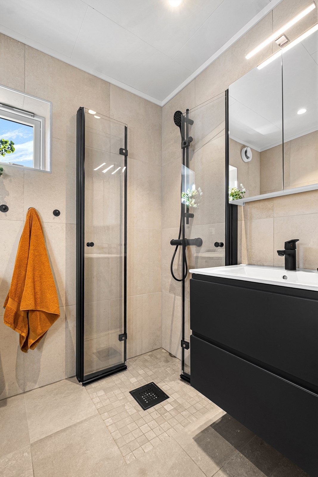 Badet har innredning med nedfelt servant, dusjhjørne og opplegg for vaskemaskin. Galleribilde