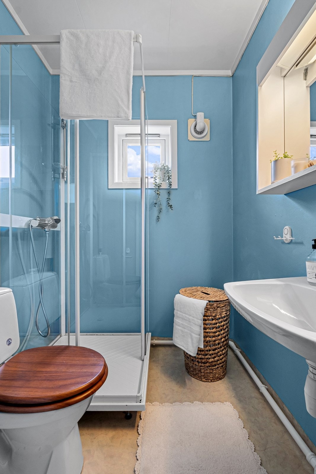 Badet i andre etasje er utstyrt med dusjkabinett, toalett og servant. Rommet har vinylbelegg på gulv og våtromstapet på veggene, og en elektrisk styrt vifte for ventilasjon. Galleribilde