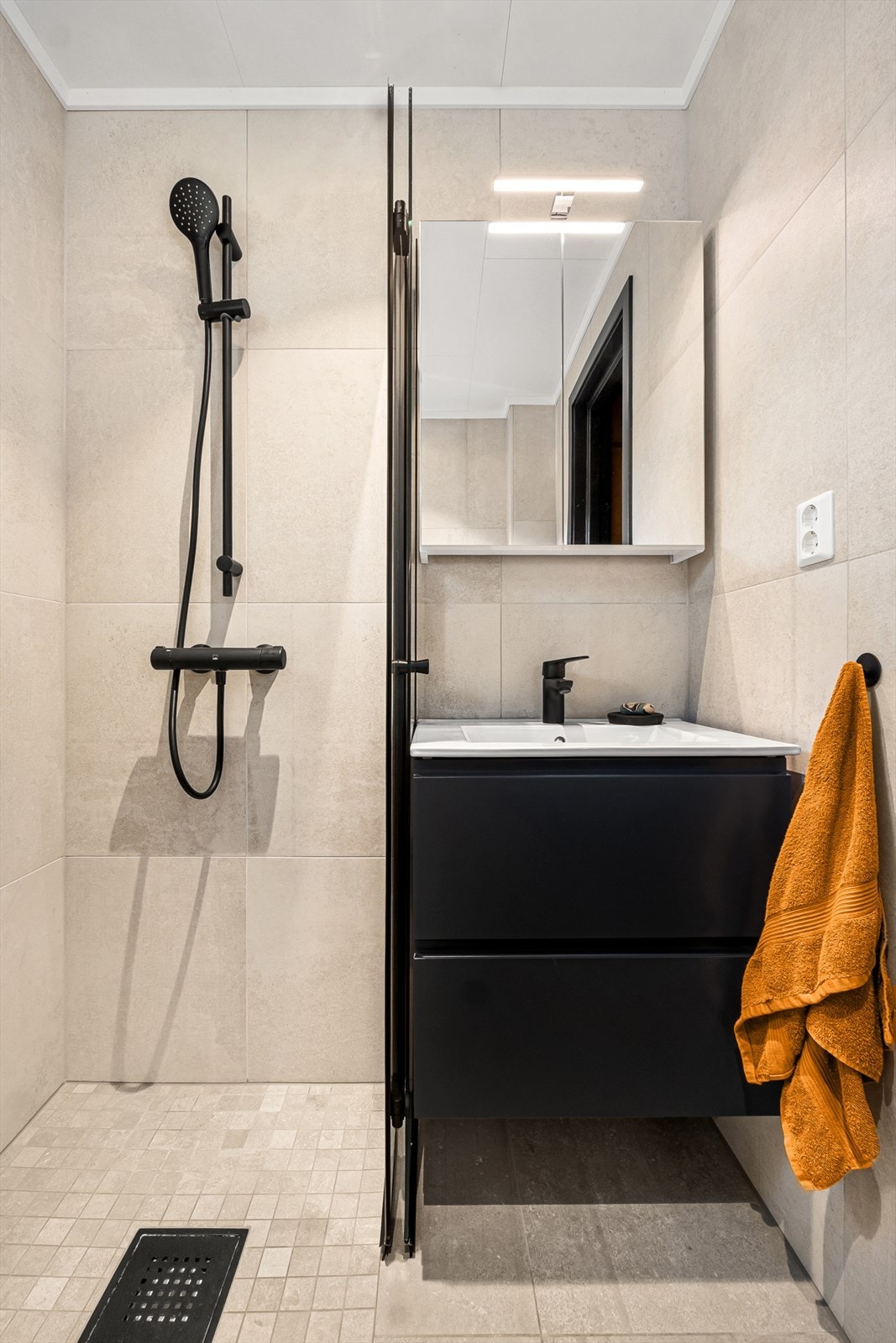 Badet har innredning med nedfelt servant, dusjhjørne og opplegg for vaskemaskin. Galleribilde