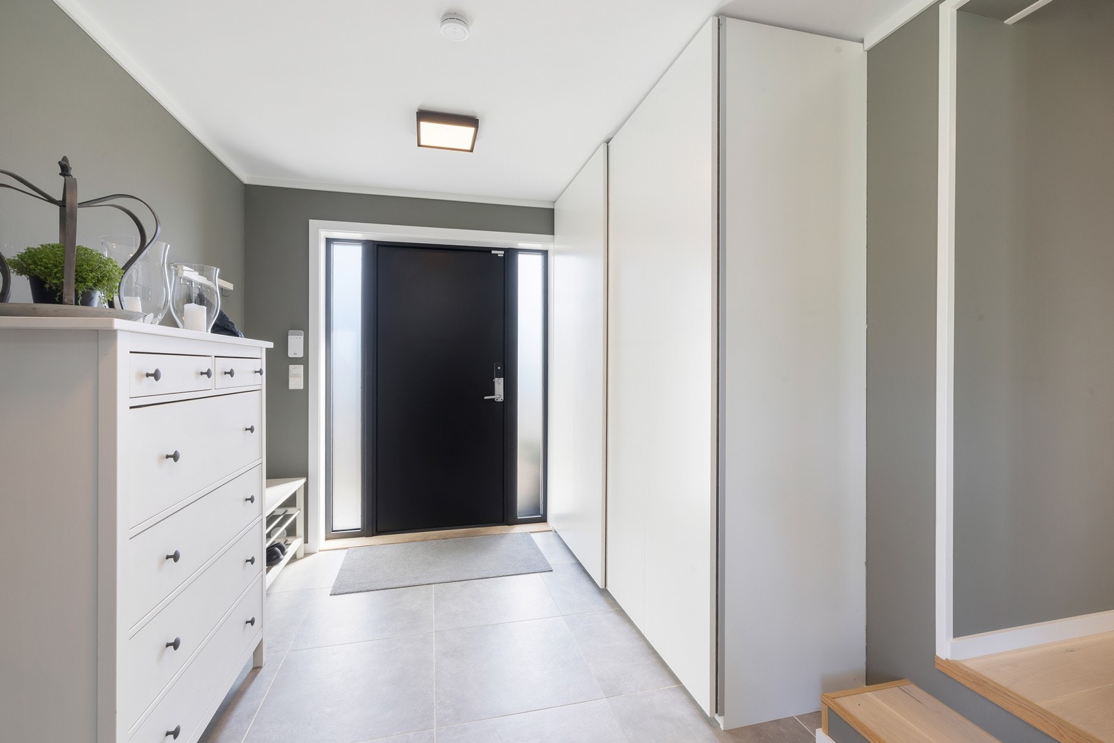 Romslig gang med fliser på gulv og skyvedørsgarderobe, Galleribilde