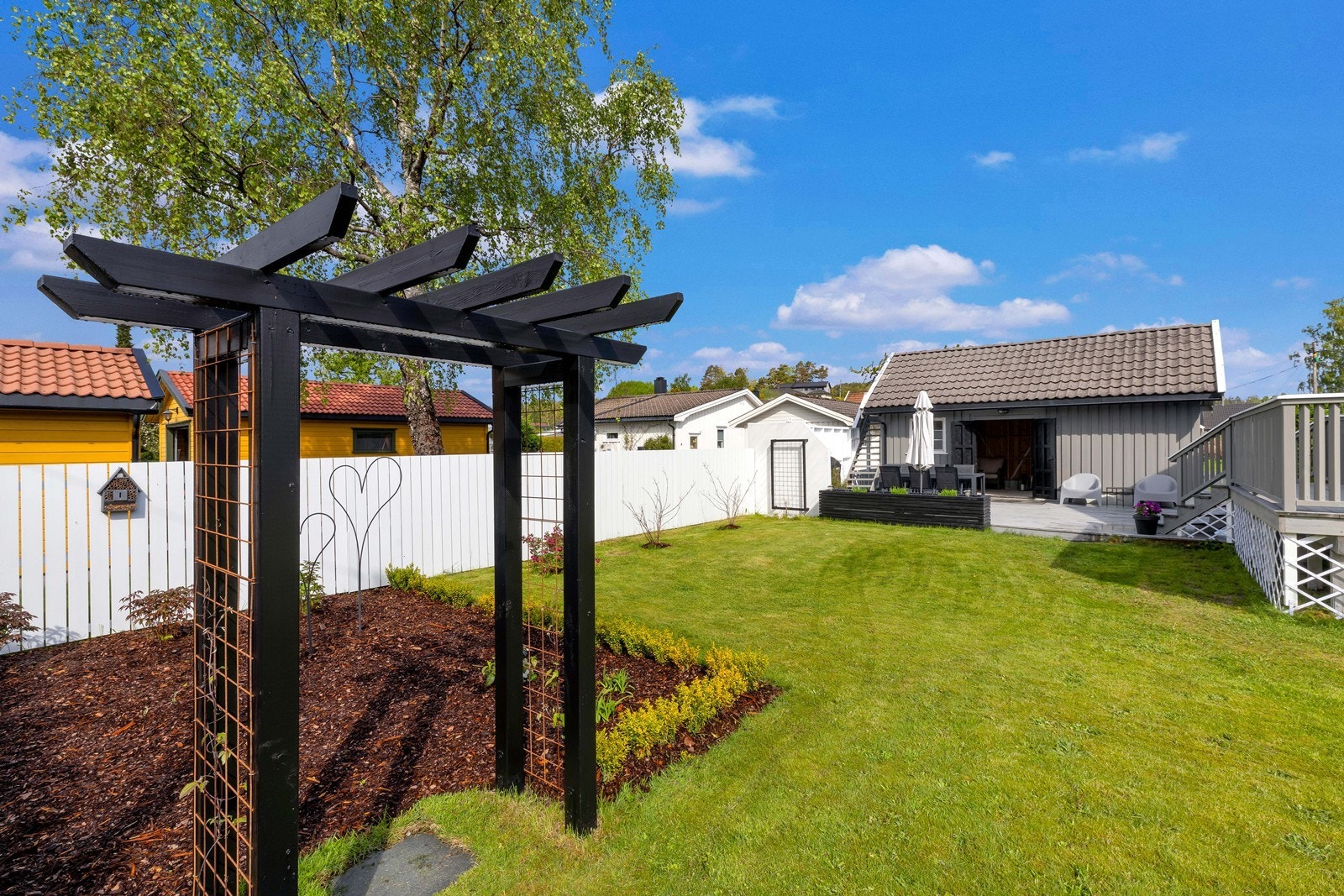 Hagen er pent opparbeidet med plen og beplantning. Galleribilde