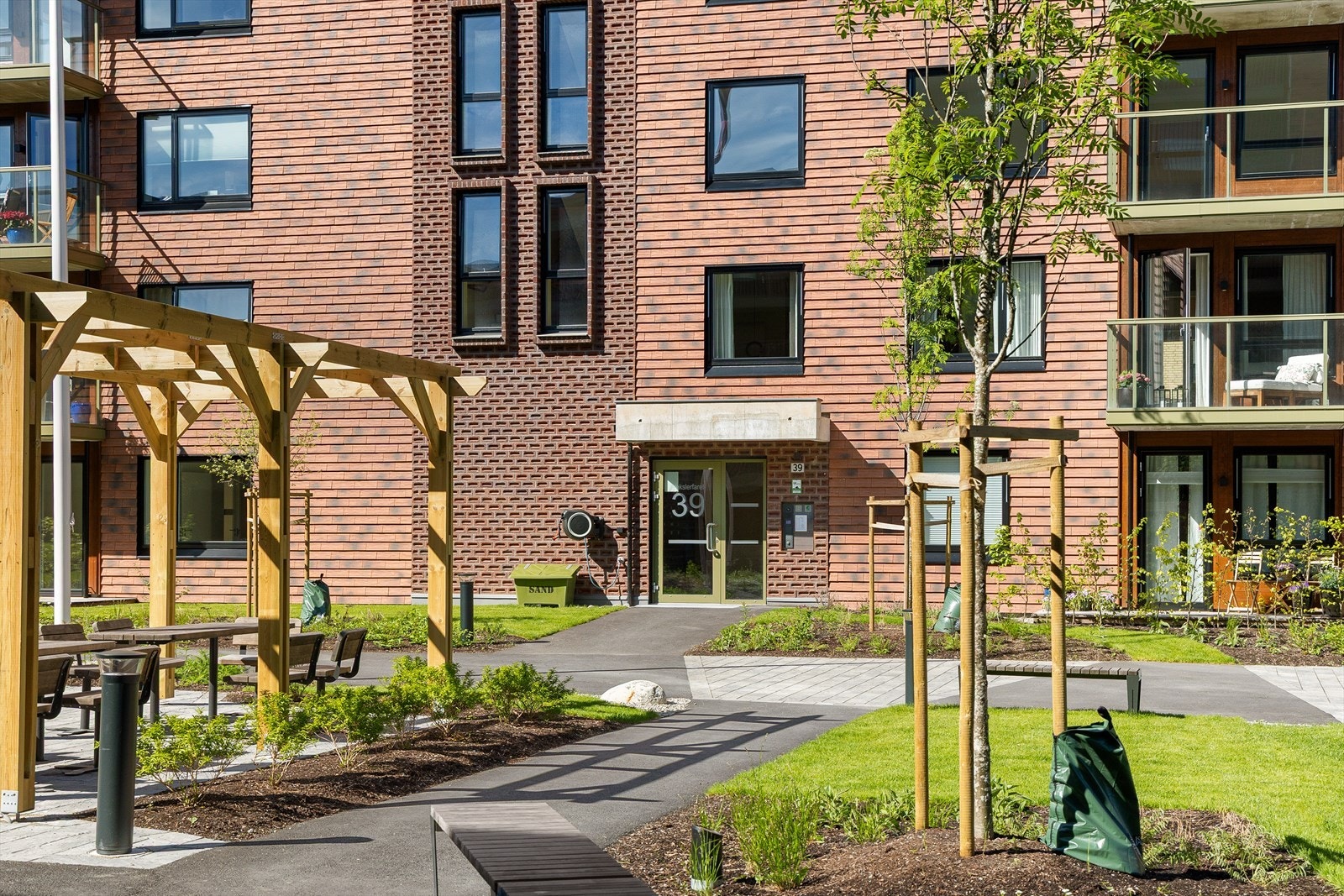 Tomten er opparbeidet med grøntområder, sittegrupper, fellesområder, lekeplasser og internveier Galleribilde
