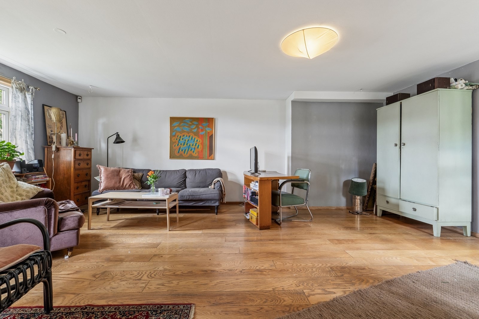 Romslig stue med parkett på gulvet og god plass til møblering. Galleribilde