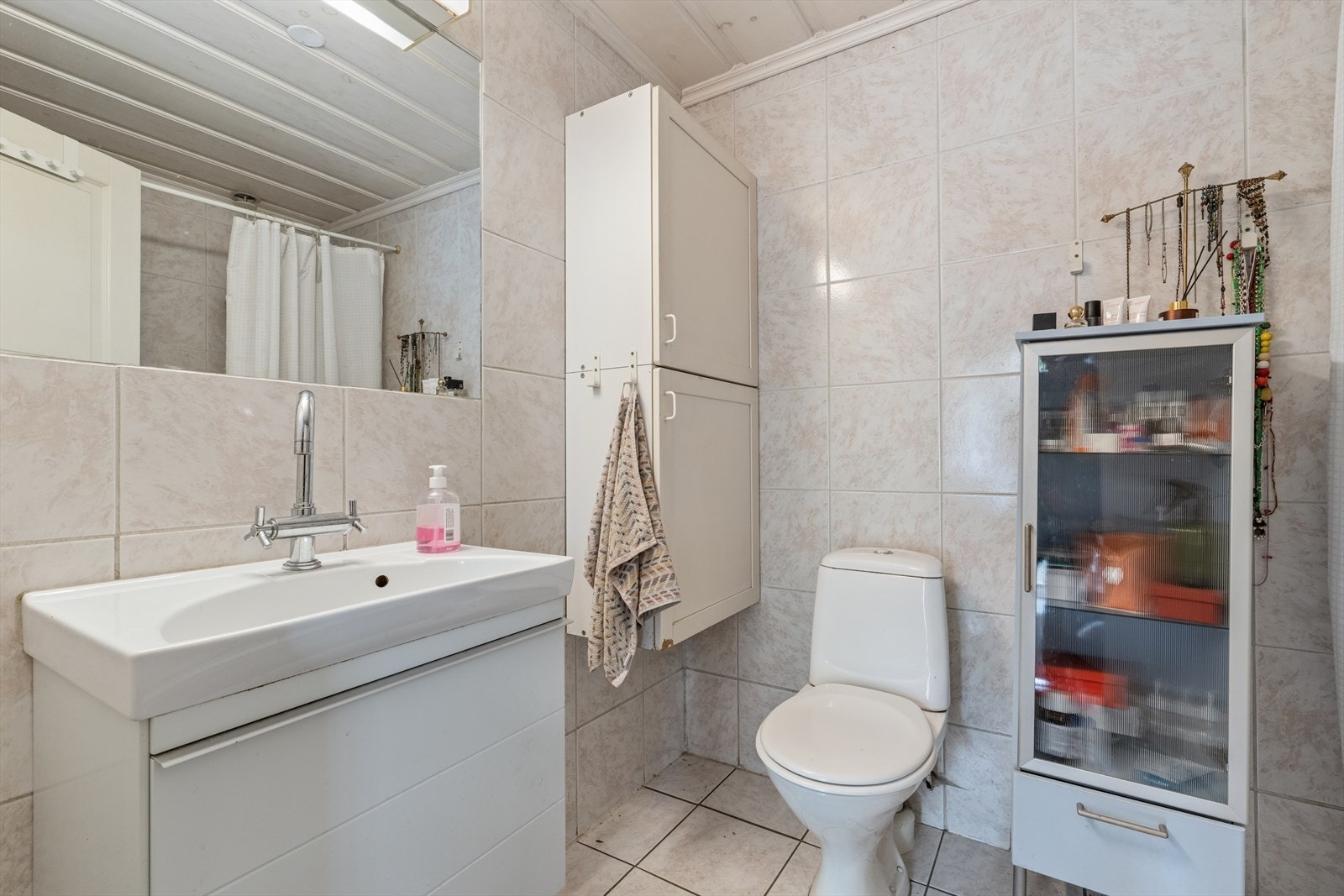 Badet i eneboligens første etasje er flislagt og har opplegg for vaskemaskin. Galleribilde