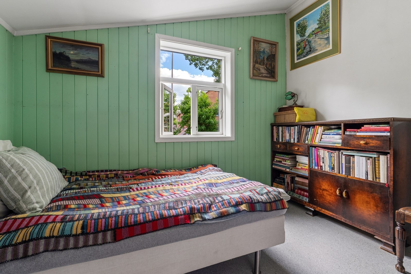 Soverom med malt trepanel og vindu som vender ut mot rolige omgivelser. Galleribilde