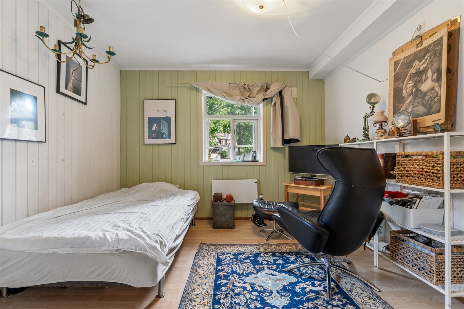 Hybel (ikke godkjent) i annekset første etasje, med panelvegger og vindu mot hagen. Galleribilde