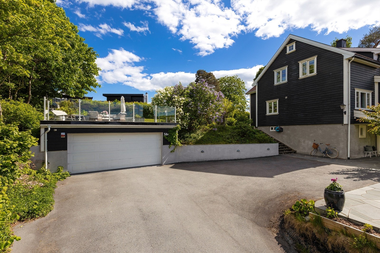Bakken opp til boligen har varmekabler for enkel adkomst også om vinteren. Her er det dobbelgarasje med lader for elbil og flere solrike uteplasser. Galleribilde