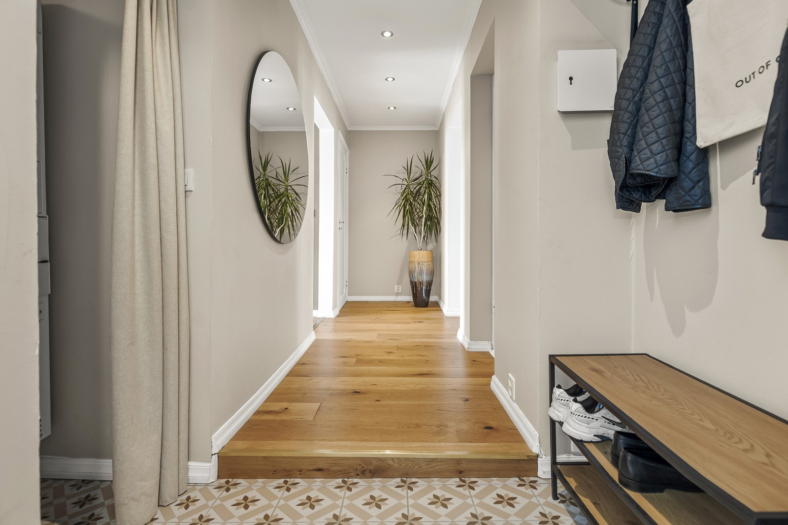 Entréen har flislagt gulv og nedforet himling med downlights, og leder videre inn i leiligheten. Galleribilde