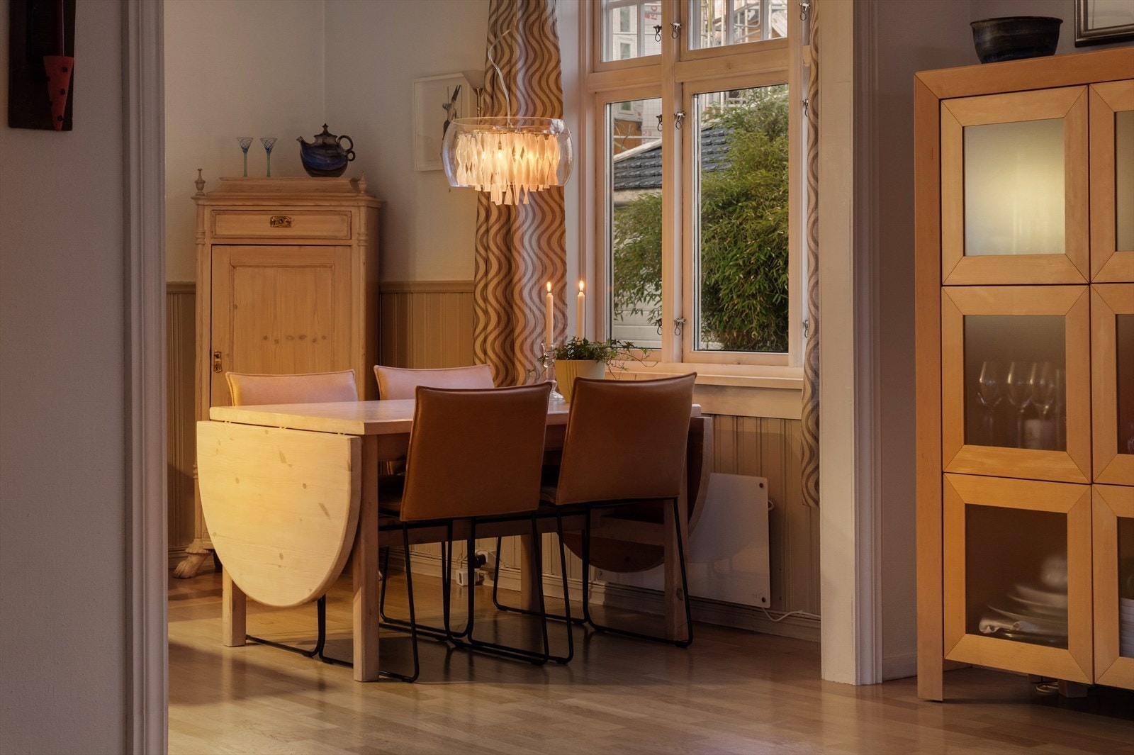 Spisestuen sett fra stuen på kveldstid. Galleribilde
