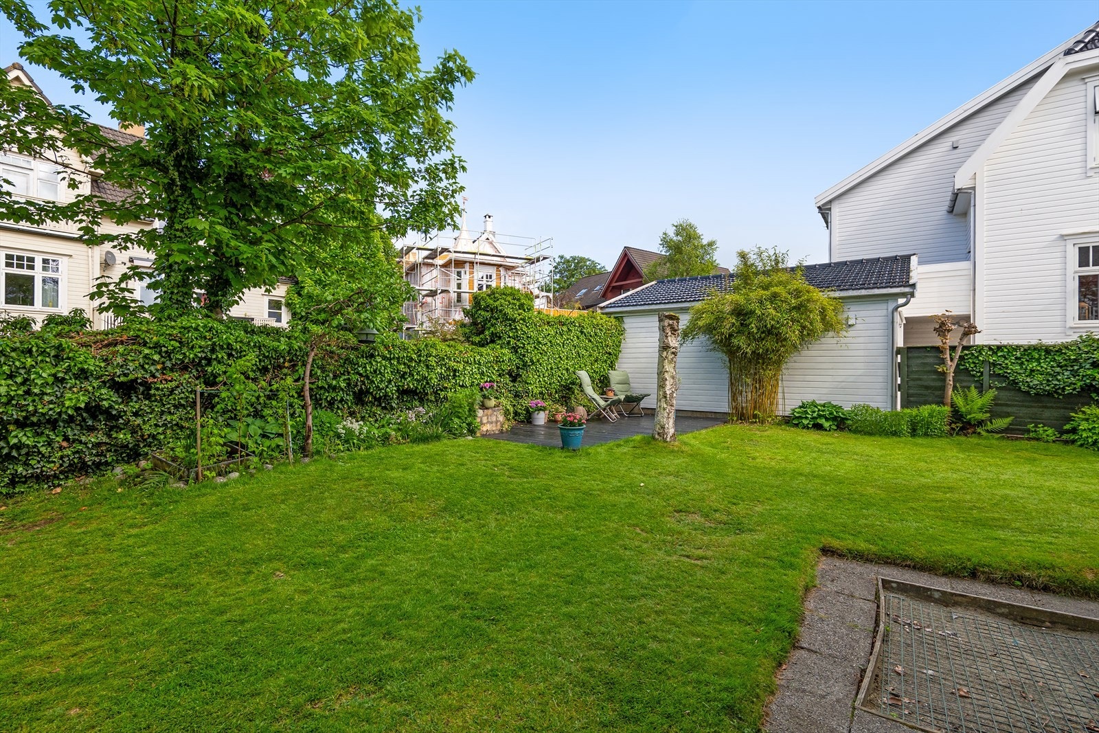 Hagen er pent opparbeidet med plen, hekk og diverse beplantning. Galleribilde