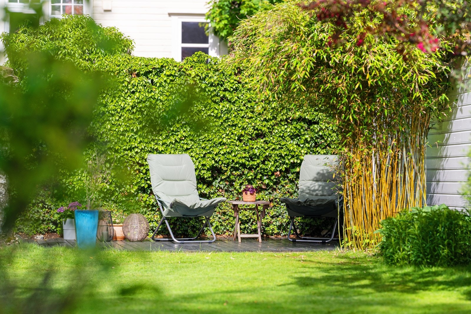 En skjermet terrasse på terreng gir en fin uteplass i hagen. Galleribilde