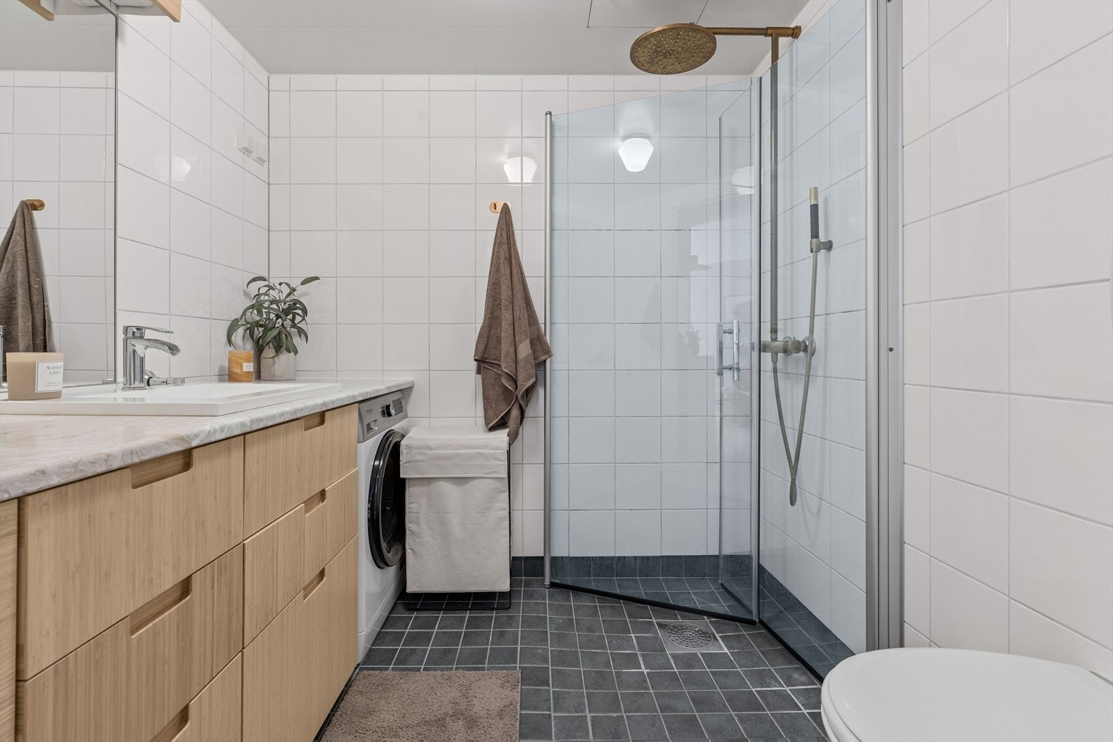 Flott og stilrent baderom med servantinnredning fra 2023, samt opplegg for vaskemaskin. Galleribilde