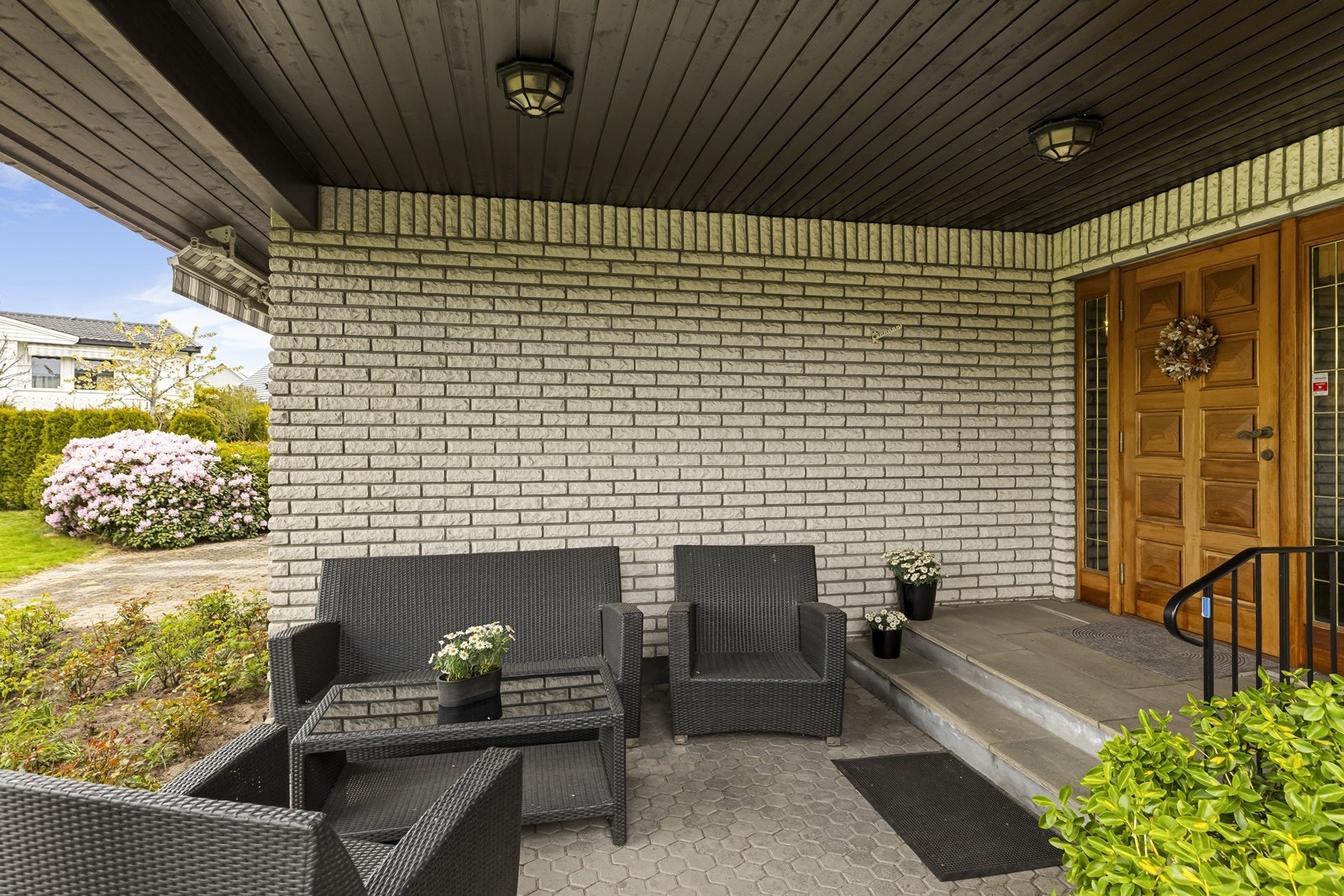 Overbygget og skjermet inngangsparti med plass til en liten sittegruppe. Galleribilde