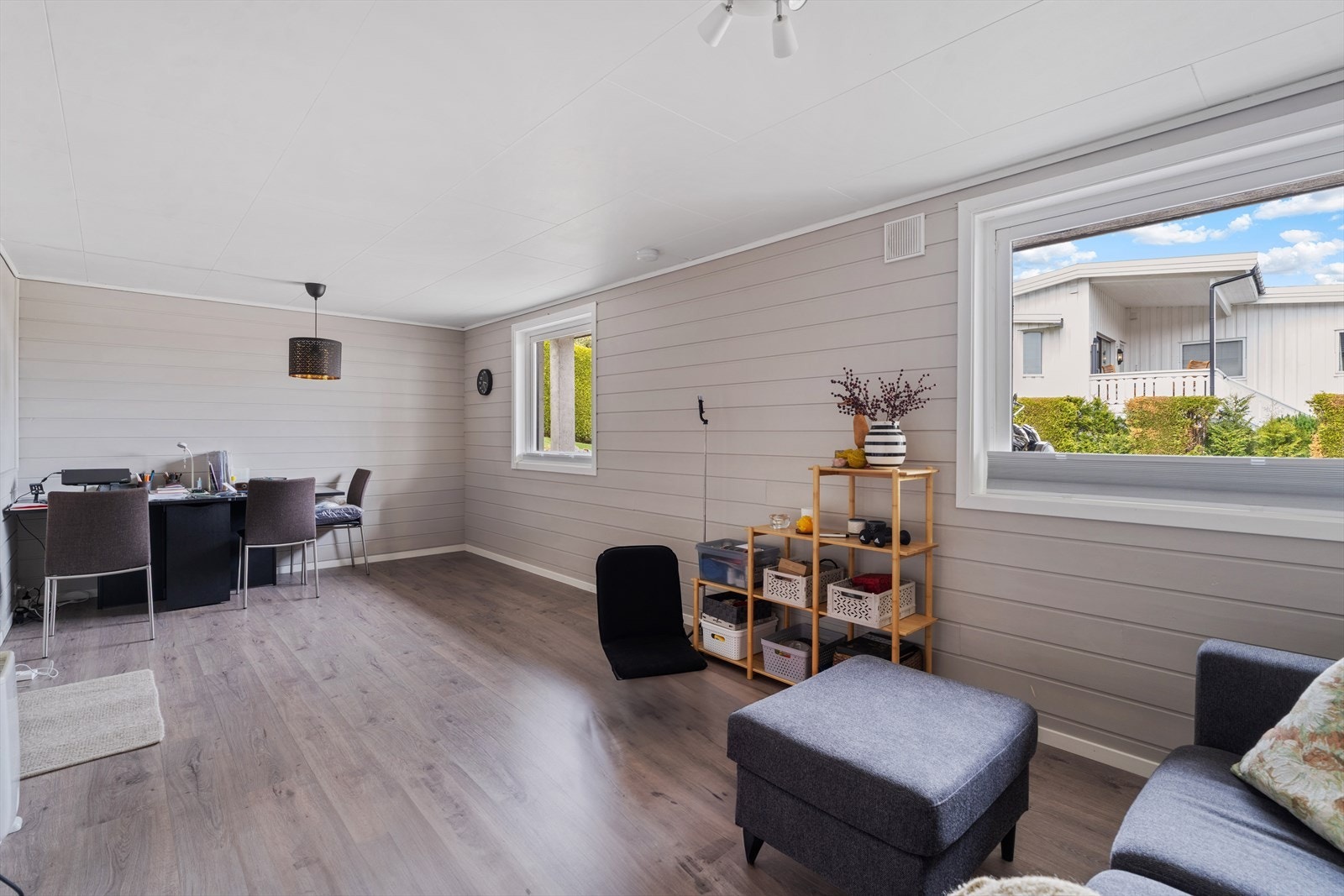 Stue i leiligheten i underetasjen, med plass til både sittegruppe og arbeidsplass. Galleribilde