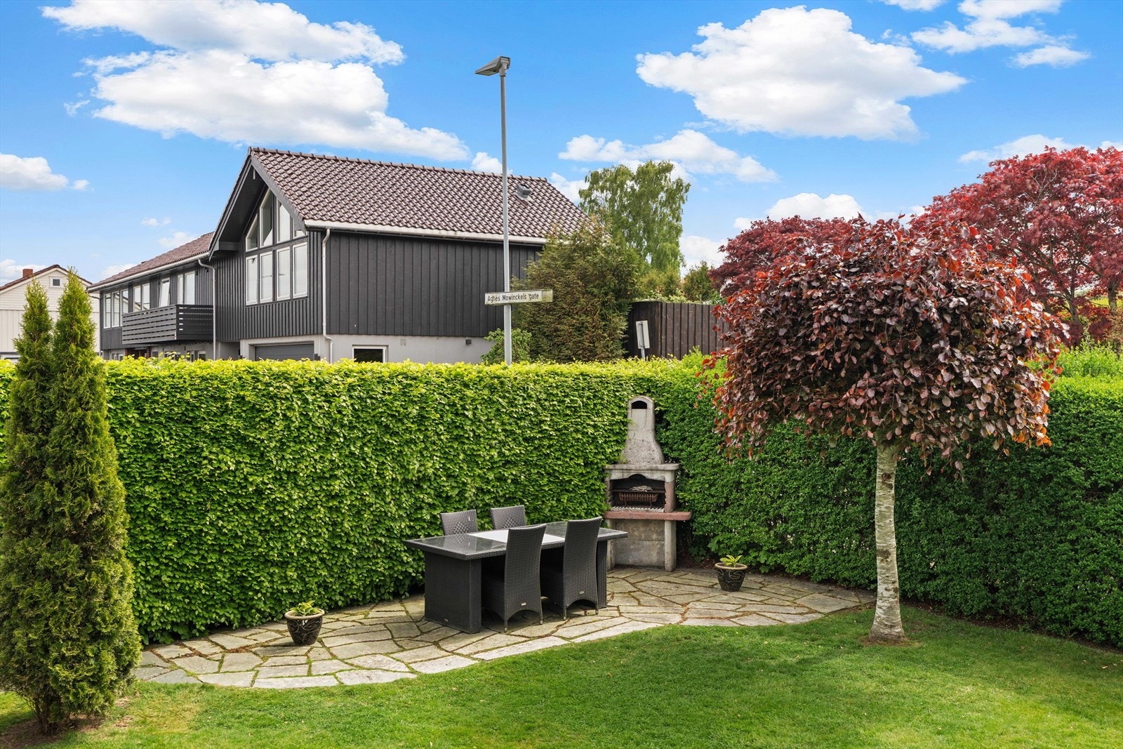 Skjermet og privat uteplass med grill, omkranset av en tett hekk. Galleribilde