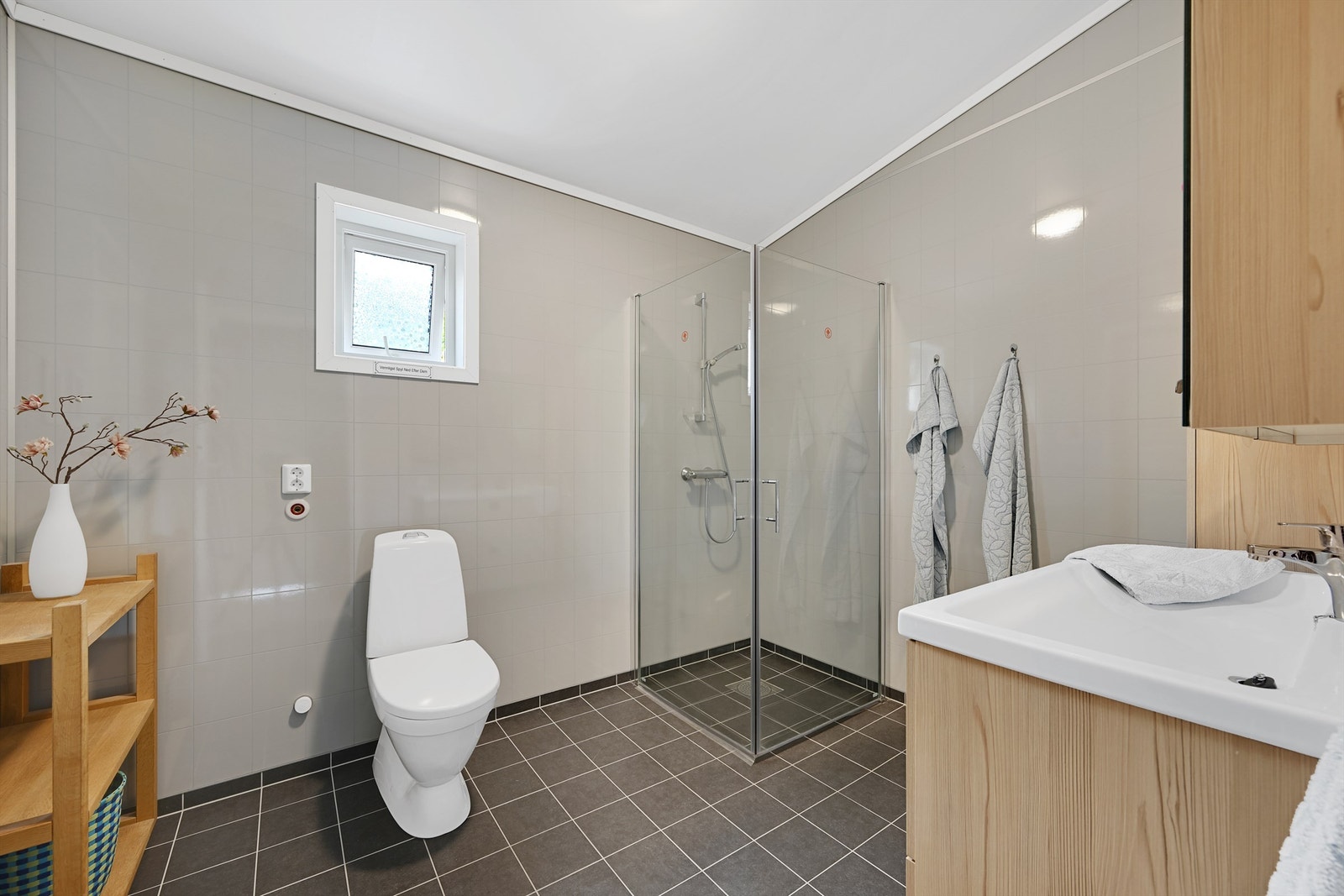 Rommet har fliser på gulv, laminerte baderomsplater på veggene og har plass/opplegg for vaskemaskin. Galleribilde