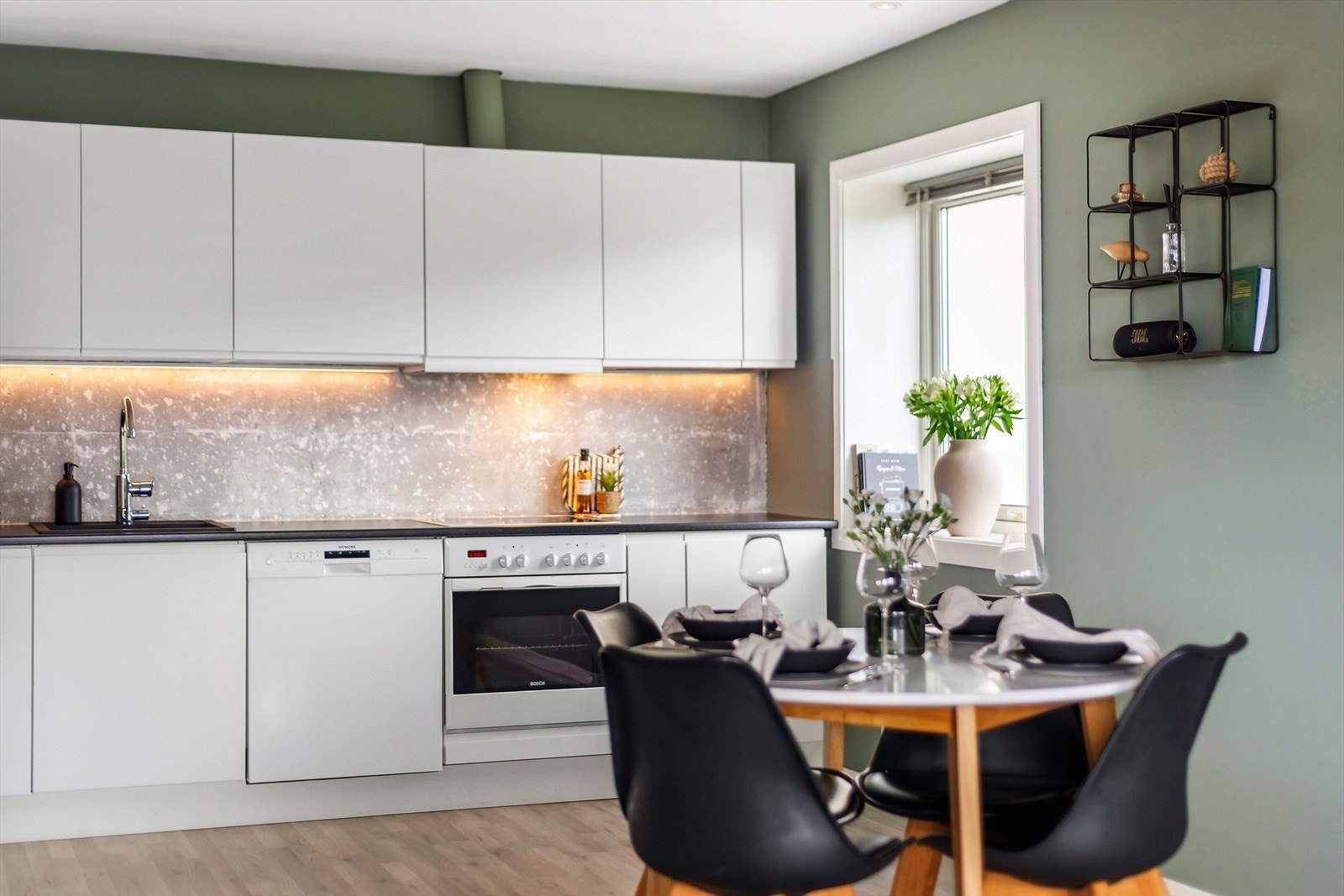 Kjøkkeninnredningen har lyse fronter og mørk, laminert benkeplate. Galleribilde