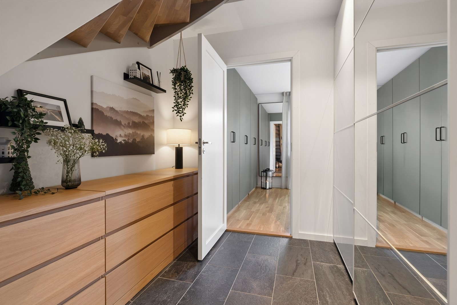 Gangen i første etasje har rikelig med oppbevaringsplass i praktisk skyvedørsgarderobe som gir plassbesparende og romslig oppbevaringsplass for både sko og yttertøy. Galleribilde
