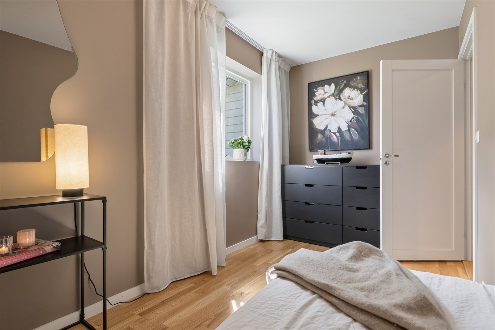 Det andre soverommet i første etasje er et mindre rom med vindu, malt i en lekker jordtone. Galleribilde