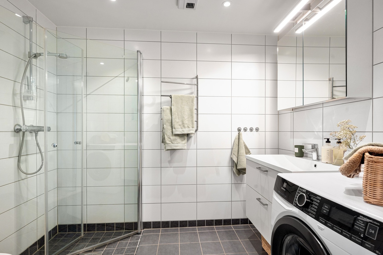 Baderom fra byggeår (2020). Badet har TG1 og byr på innredning med nedfelt servant, veggmontert toalett, dusjvegger/hjørne og opplegg for vaskemaskin Galleribilde