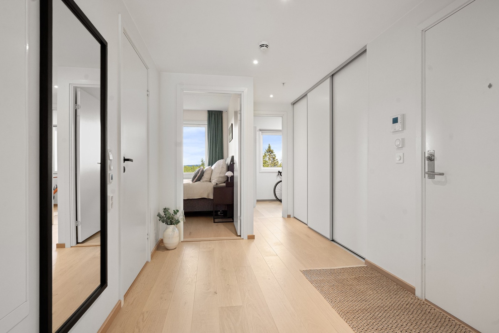 Stor skyvedørsgarderobe i gang som inneholder strømuttak og lys Galleribilde