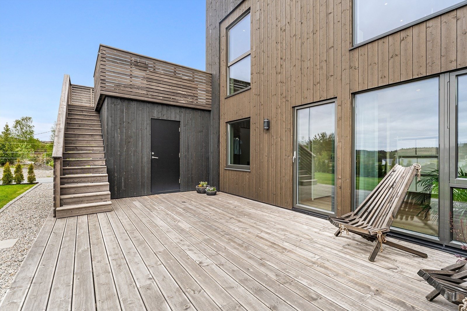 Stor terrasse i trematerialer med utgang fra første etasje. Galleribilde