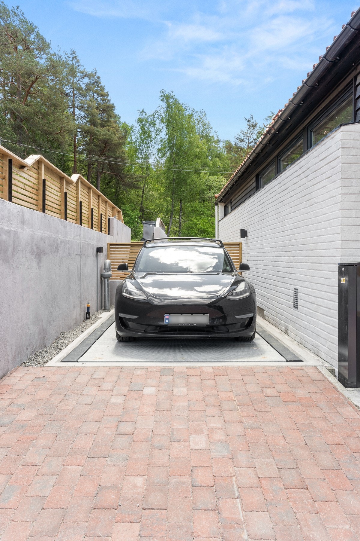 Boligen har parkering med plass til 2 biler i bilheis/løfteplattform fra 2025. Galleribilde