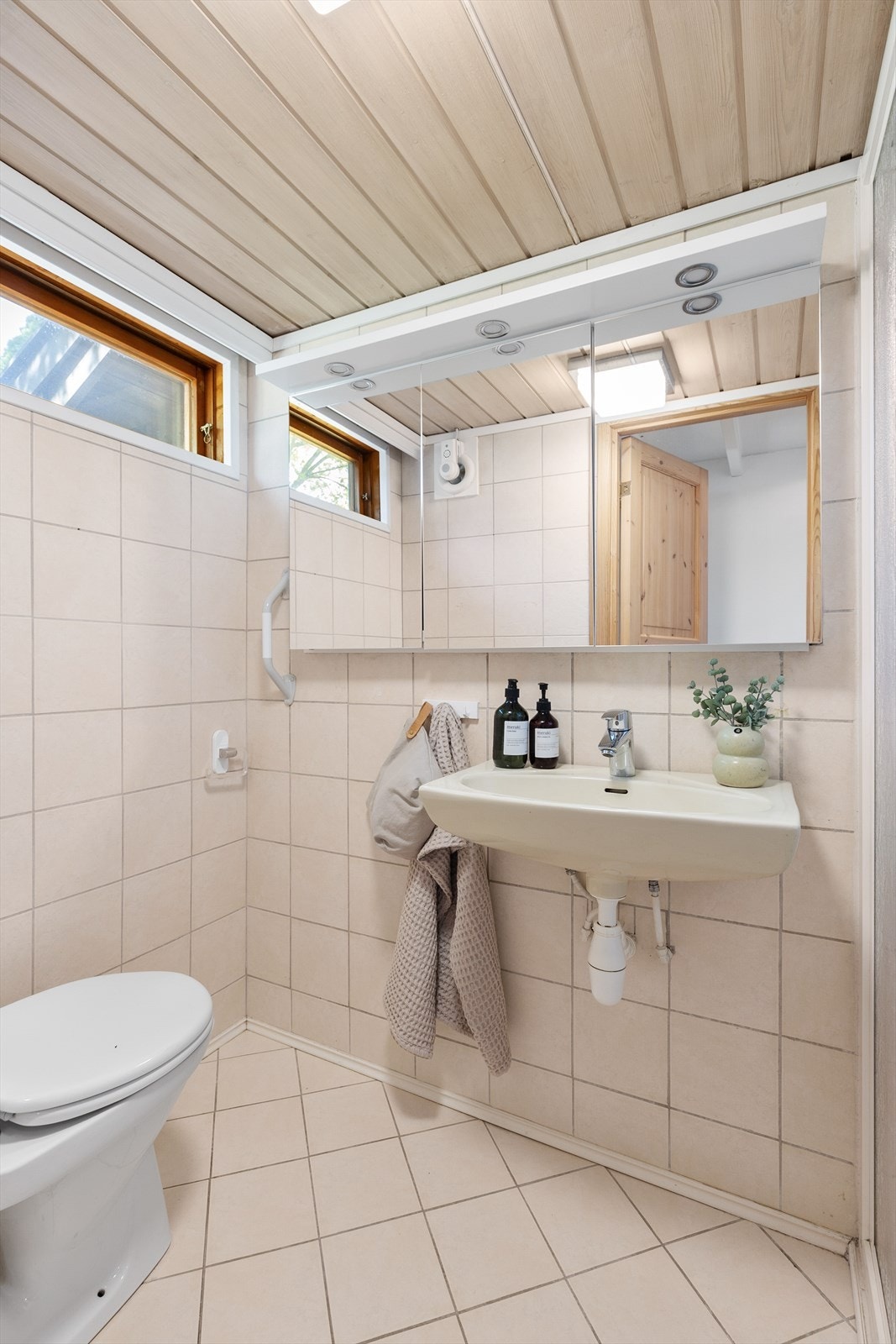 Badet er utstyrt med vegghengt servant, speilskap med belysning og toalett. Galleribilde