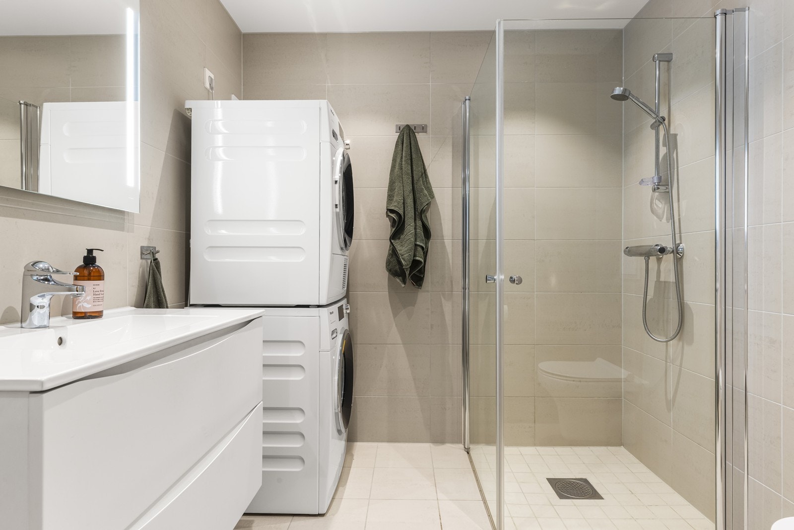 Badet har dusjhjørne med innfellbare glassdører og opplegg for vaskemaskin. Galleribilde