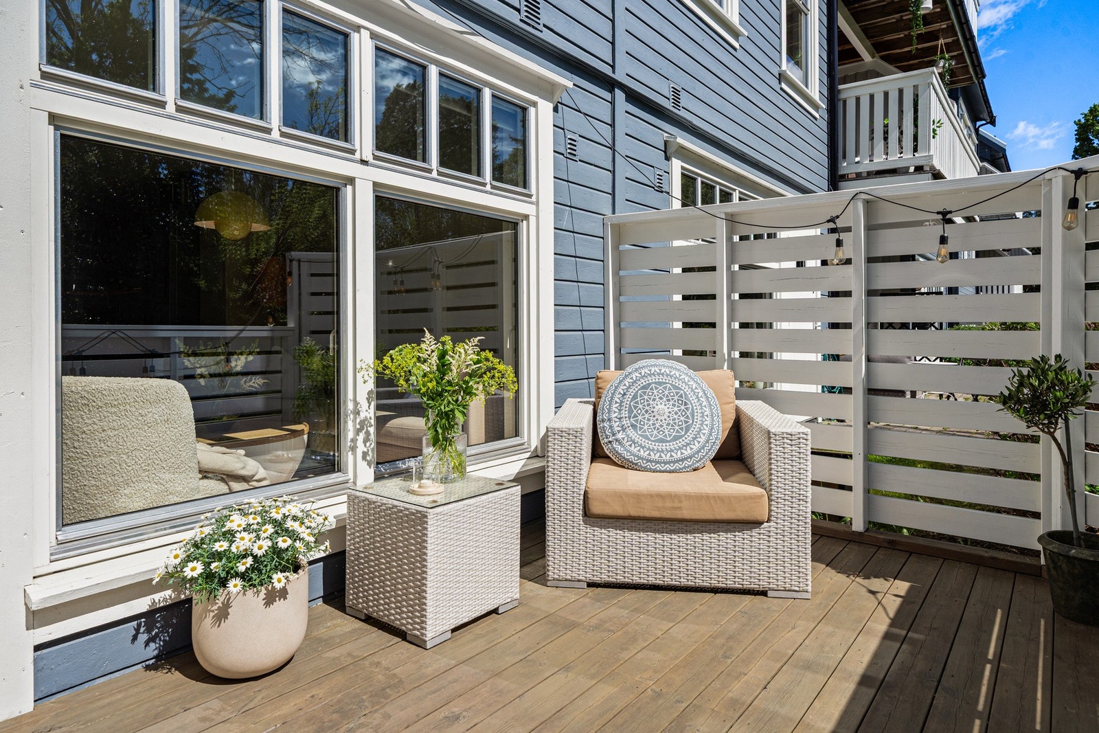 Solrik og innbydende terrasse med god plass til avslapning - her nytes sommerens beste dager i le og med grønt utsyn. Galleribilde