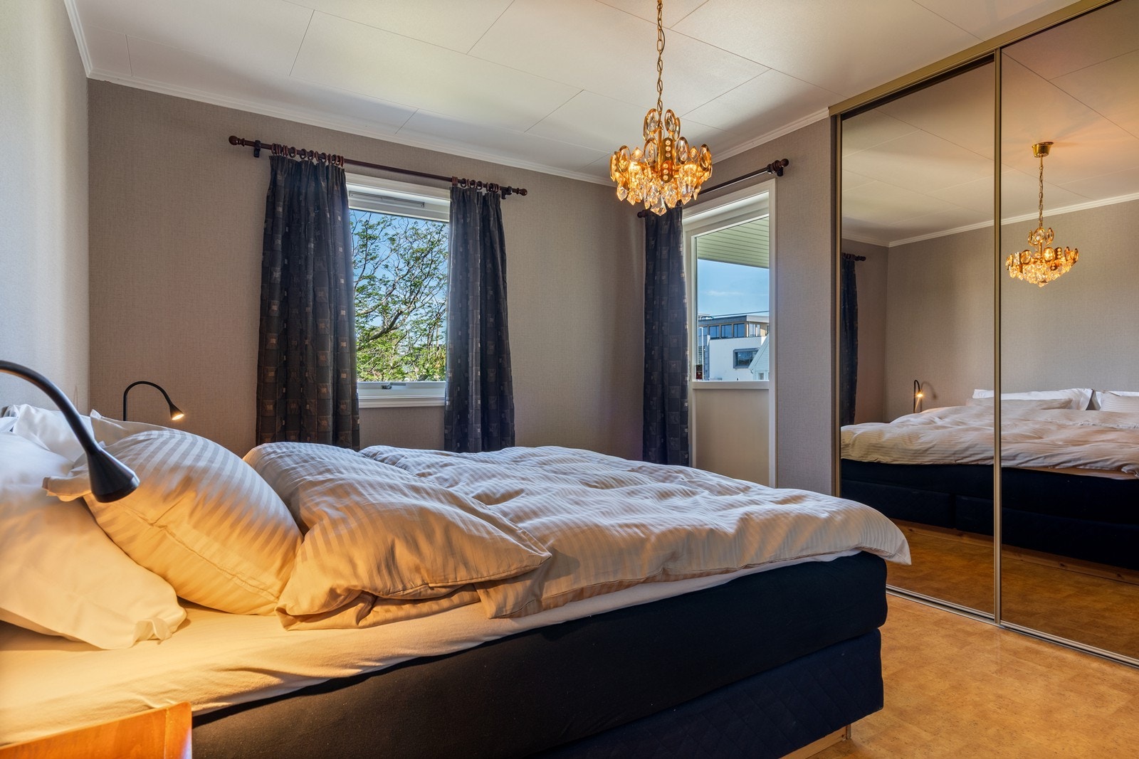 Soverom i første etasje med skyvedørsgarderobe. Utgang til uteområdet via dør. Veggoverflater er nylig tapetsert (2026). Galleribilde