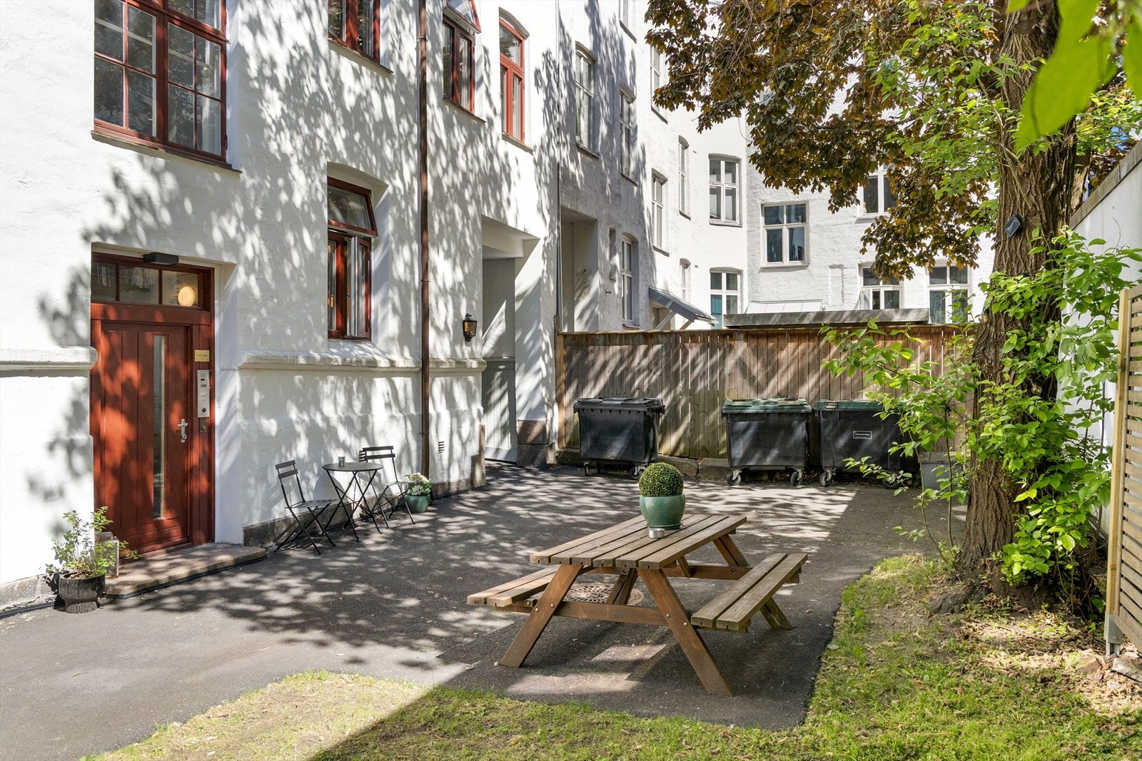 Skjermet bakgård med benk og grønne omgivelser. Galleribilde