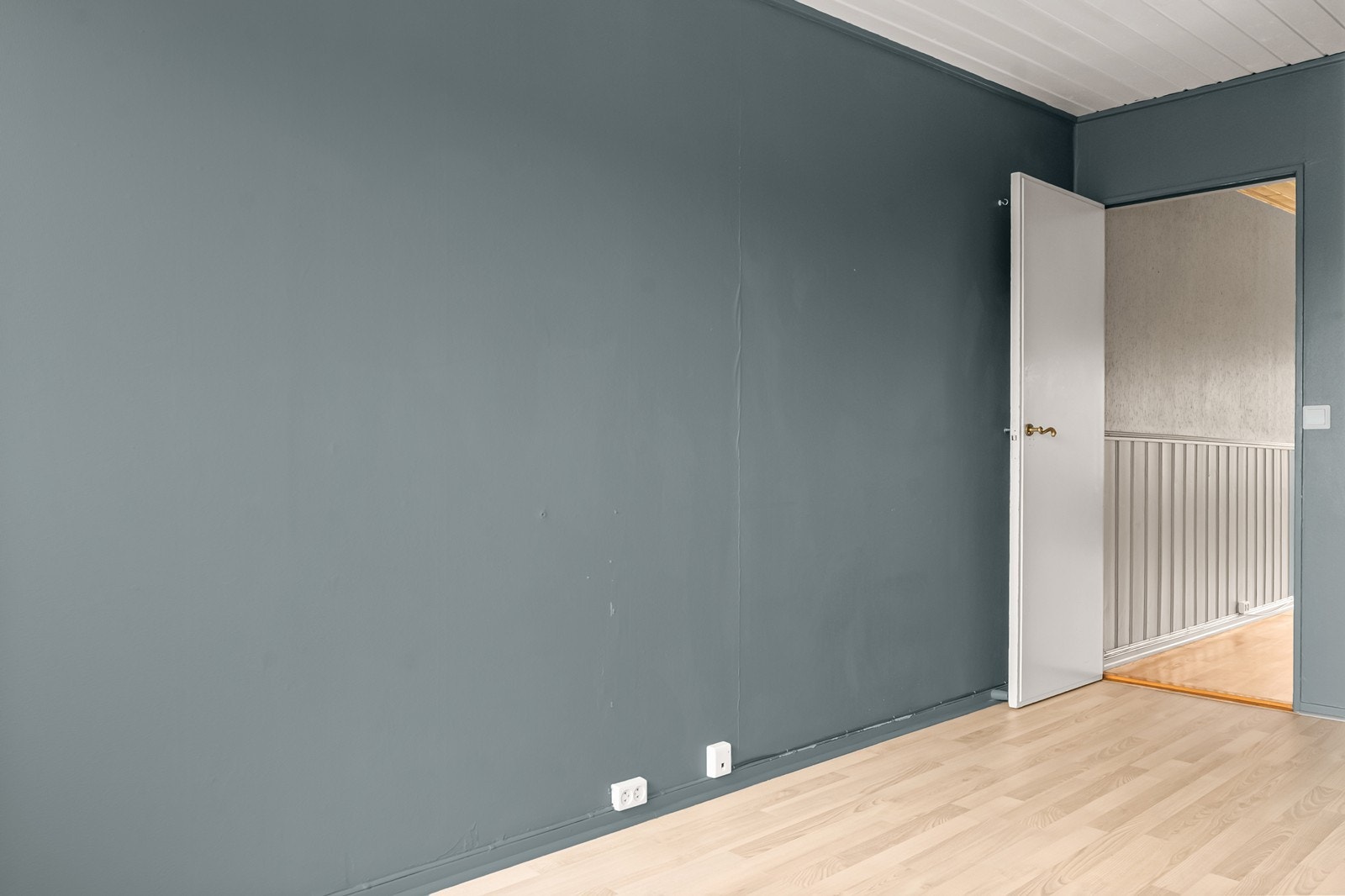 Rommet har laminatgulv, malte flater og panel i himlingen. Galleribilde