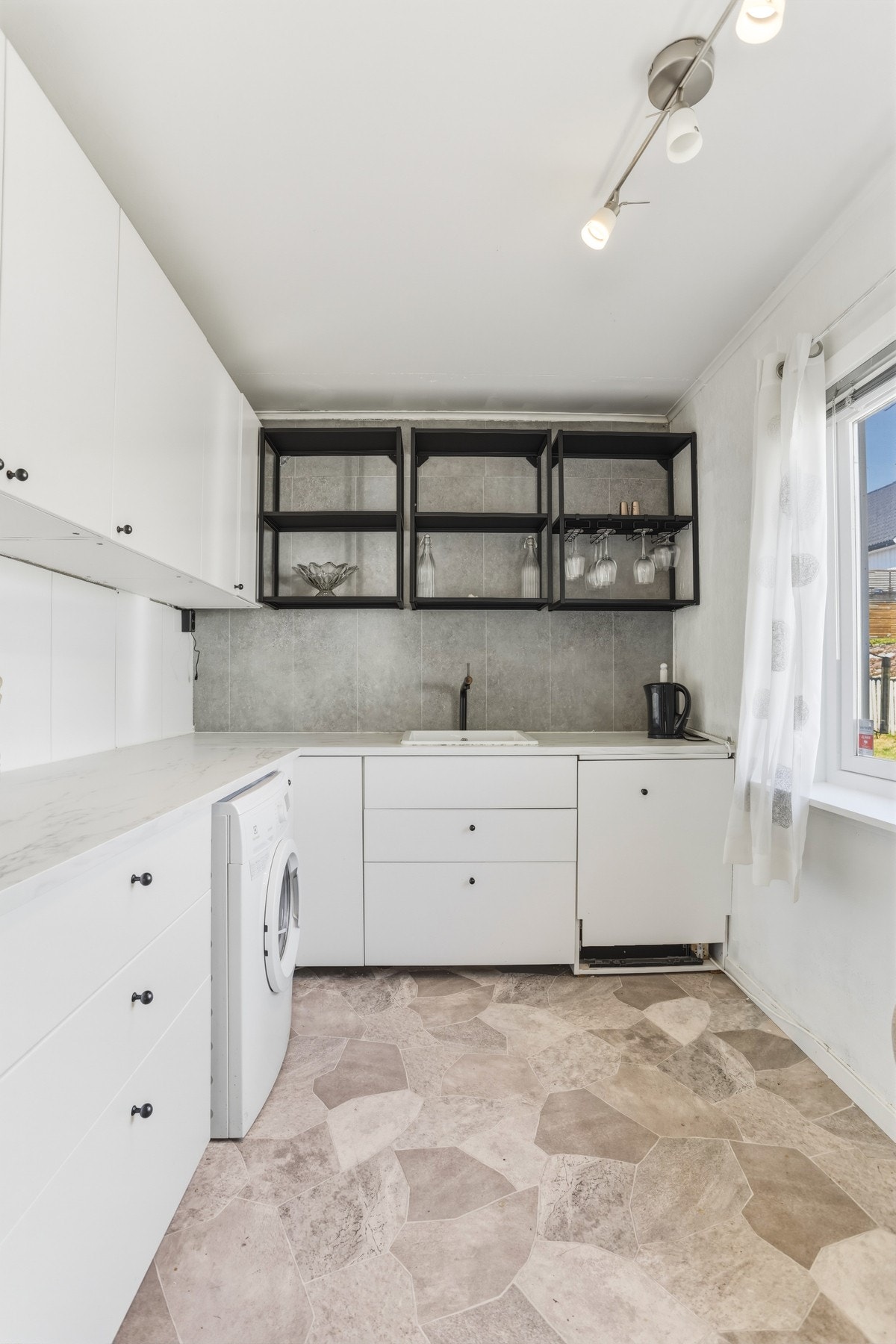 Innredningen har plass for frittstående hvitevarer og har opplegg for både oppvaskmaskin og vaskemaskin. Galleribilde