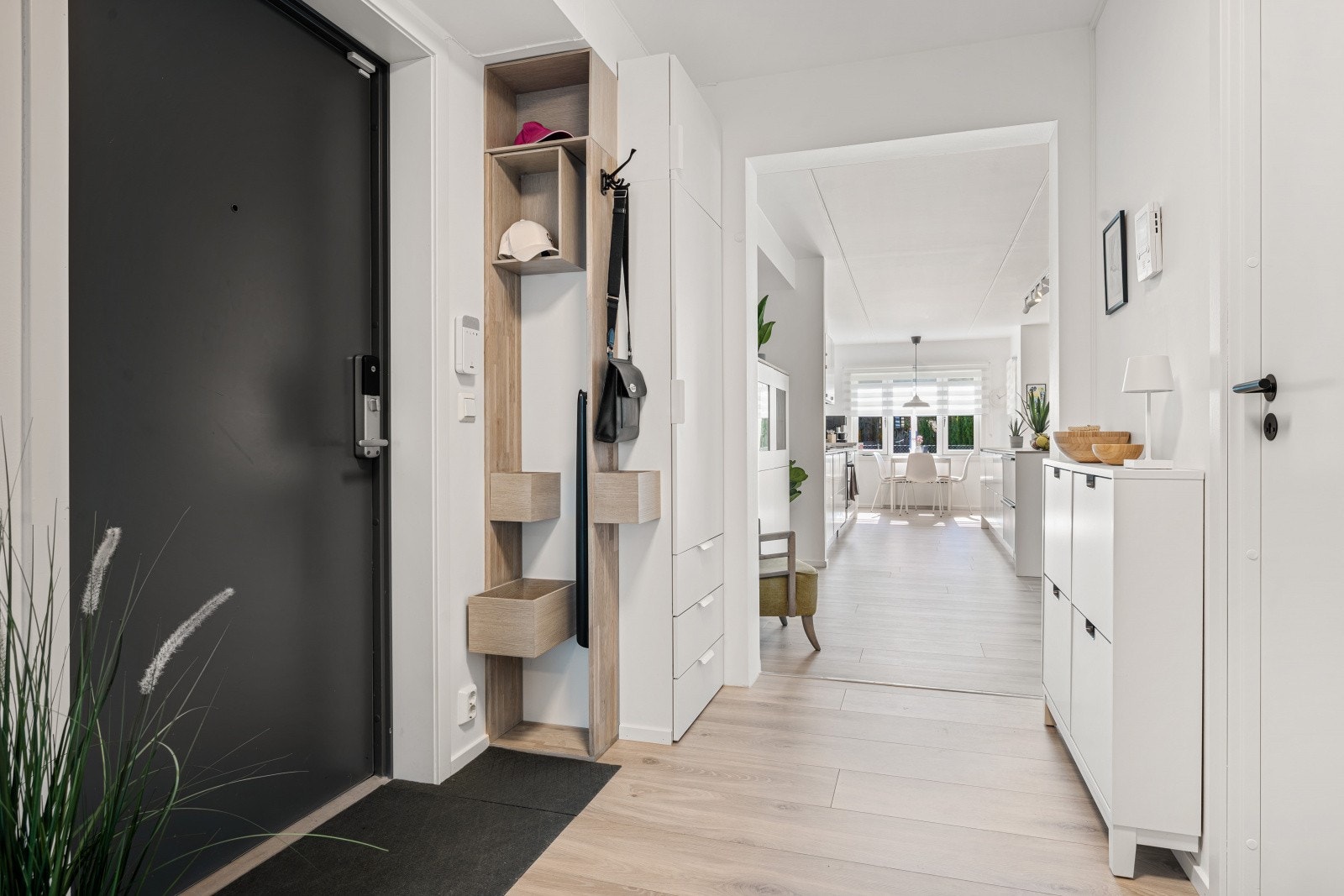 Lys og innbydende entré med moderne uttrykk og tilpasset oppbevaringsreol. Leiligheten ligger praktisk til på bakkeplan og har porttelefon for enkel og trygg adkomst. Galleribilde