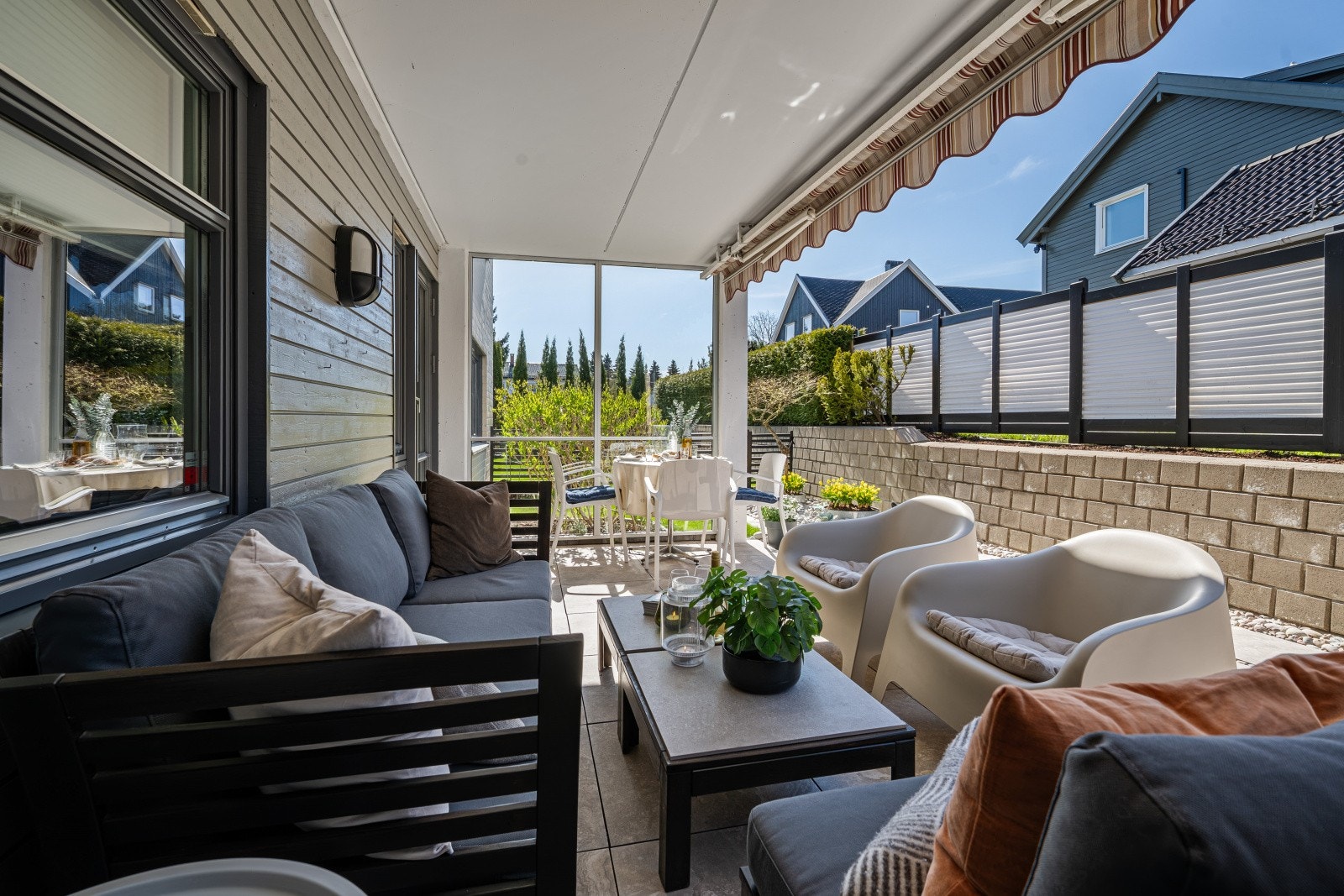 Romslig og overbygget uteplass med god plass til både lounge og spisegruppe - perfekt for lange sommerkvelder. Galleribilde