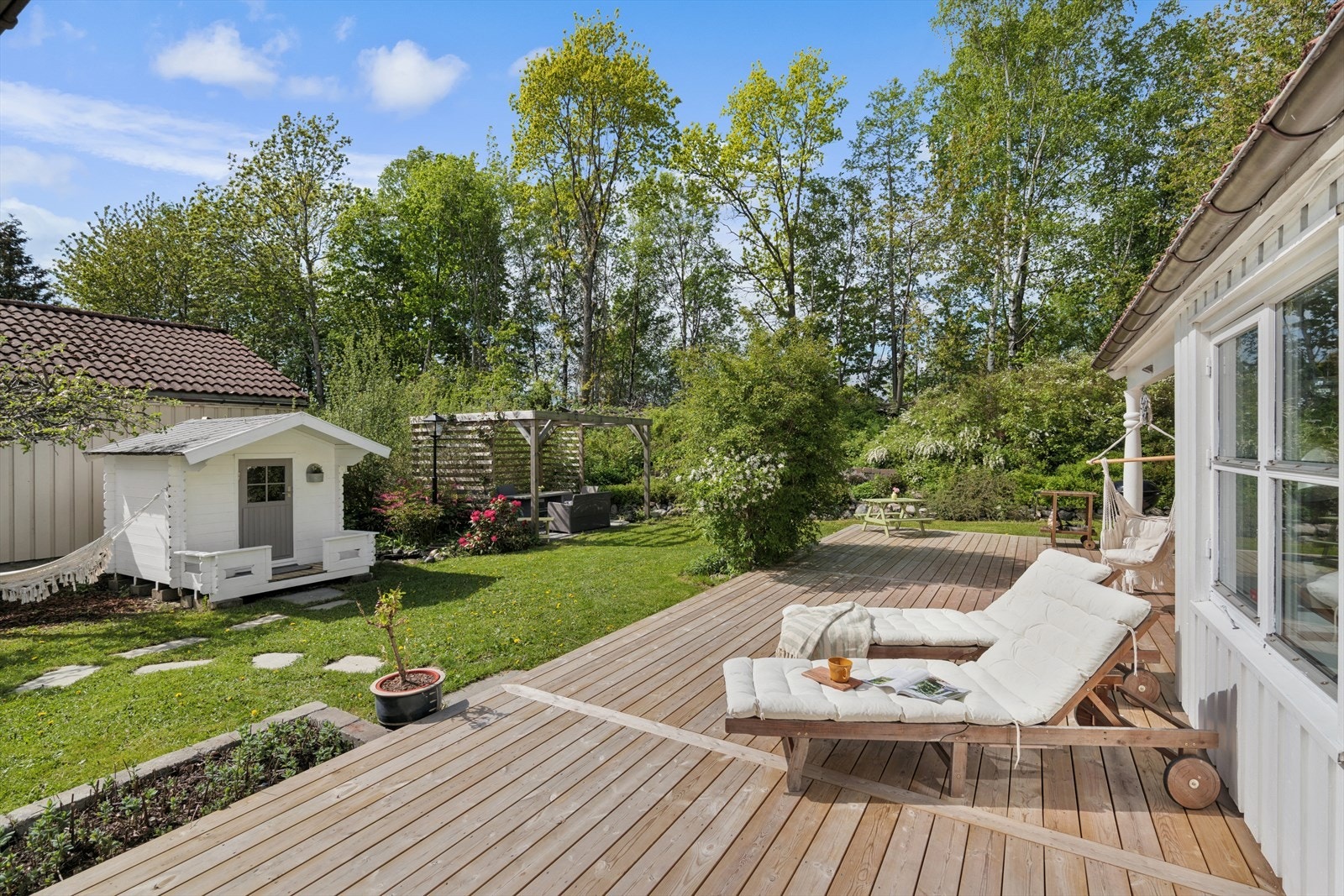 Stor og solrik terrasseplatting med rikelig plass til møblering og flere soner. Her ligger alt til rette for avslapning i rolige omgivelser. Galleribilde