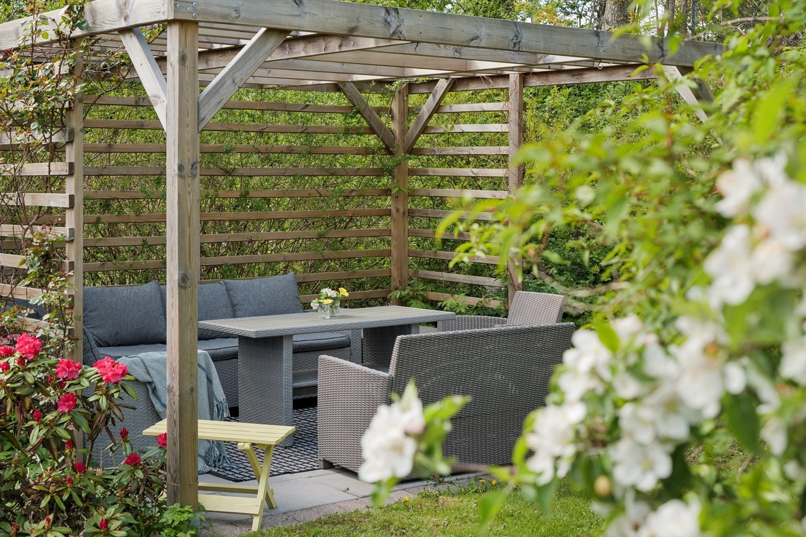 Pergolaen skaper et hyggelig uterom med skjerming og atmosfære - perfekt for lange sommerkvelder. Galleribilde