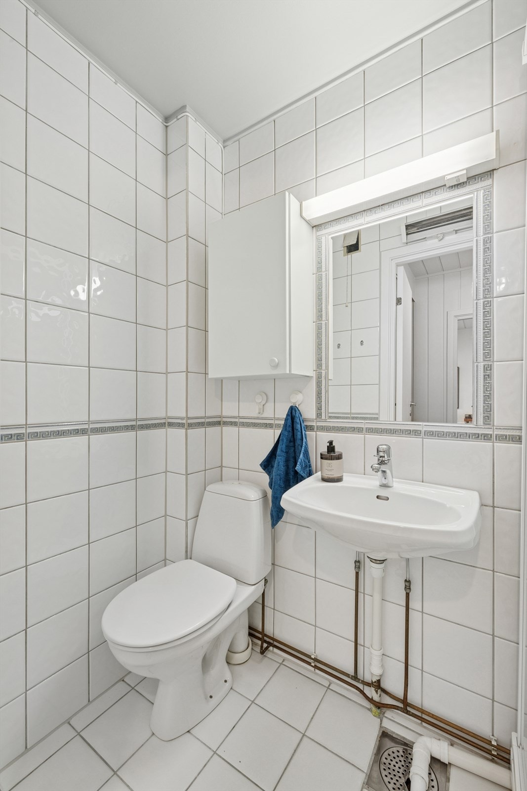 Badet har funksjonell innredning med lyse fliser. Galleribilde