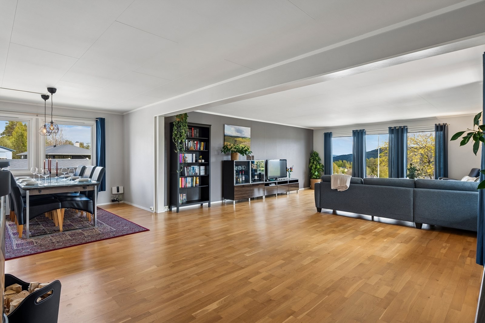 Den romslige stuen gir fleksibilitet med god plass til både en stor sofagruppe og en egen spisesone. Galleribilde