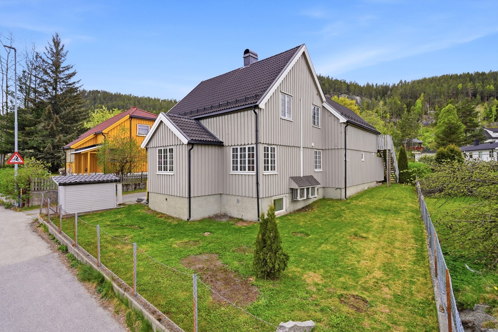Boligen sett fra Sandsværveien, med flat og fin tomt med mye god boltreplass. Galleribilde