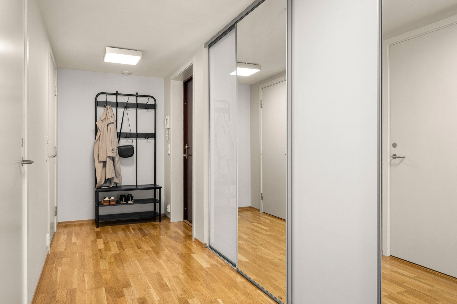 Romslig gang med skyvedørsgarderobe for effektiv oppbevaring av yttertøy og sko. Galleribilde