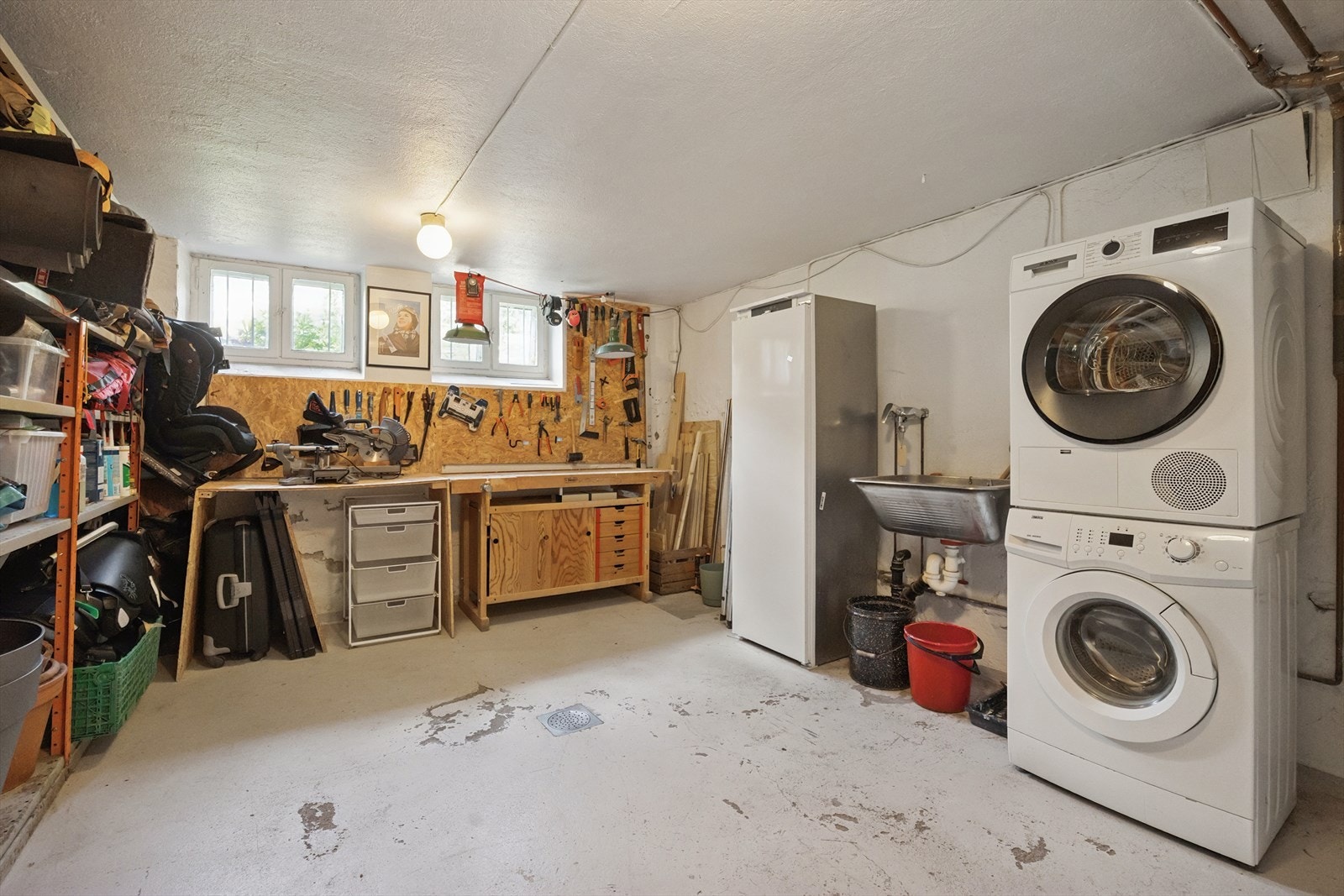 Boligen disponerer ca. 35 kvm kjellerareal. Ett av rommene er innredet med vaskemaskin, fryser, hylleanordninger og diverse verktøy. Galleribilde