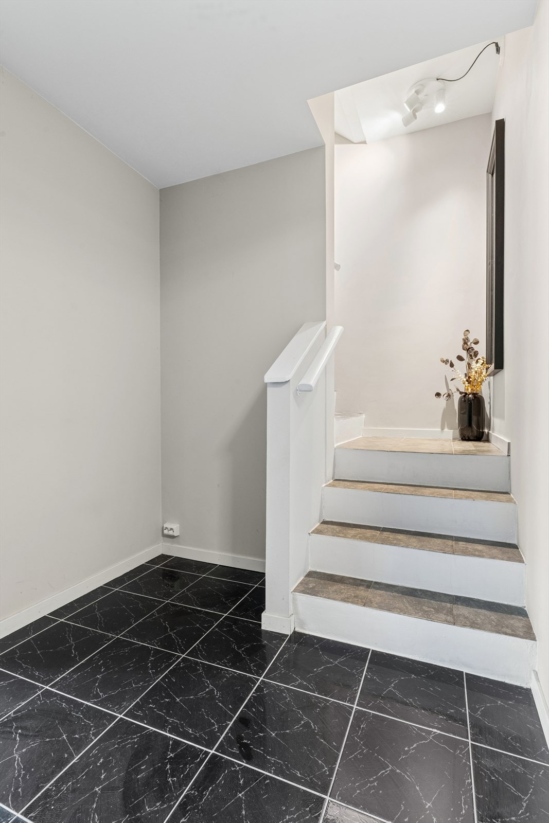 En solid betongtrapp med fliser i inntrinnene knytter de to etasjene sammen. Galleribilde