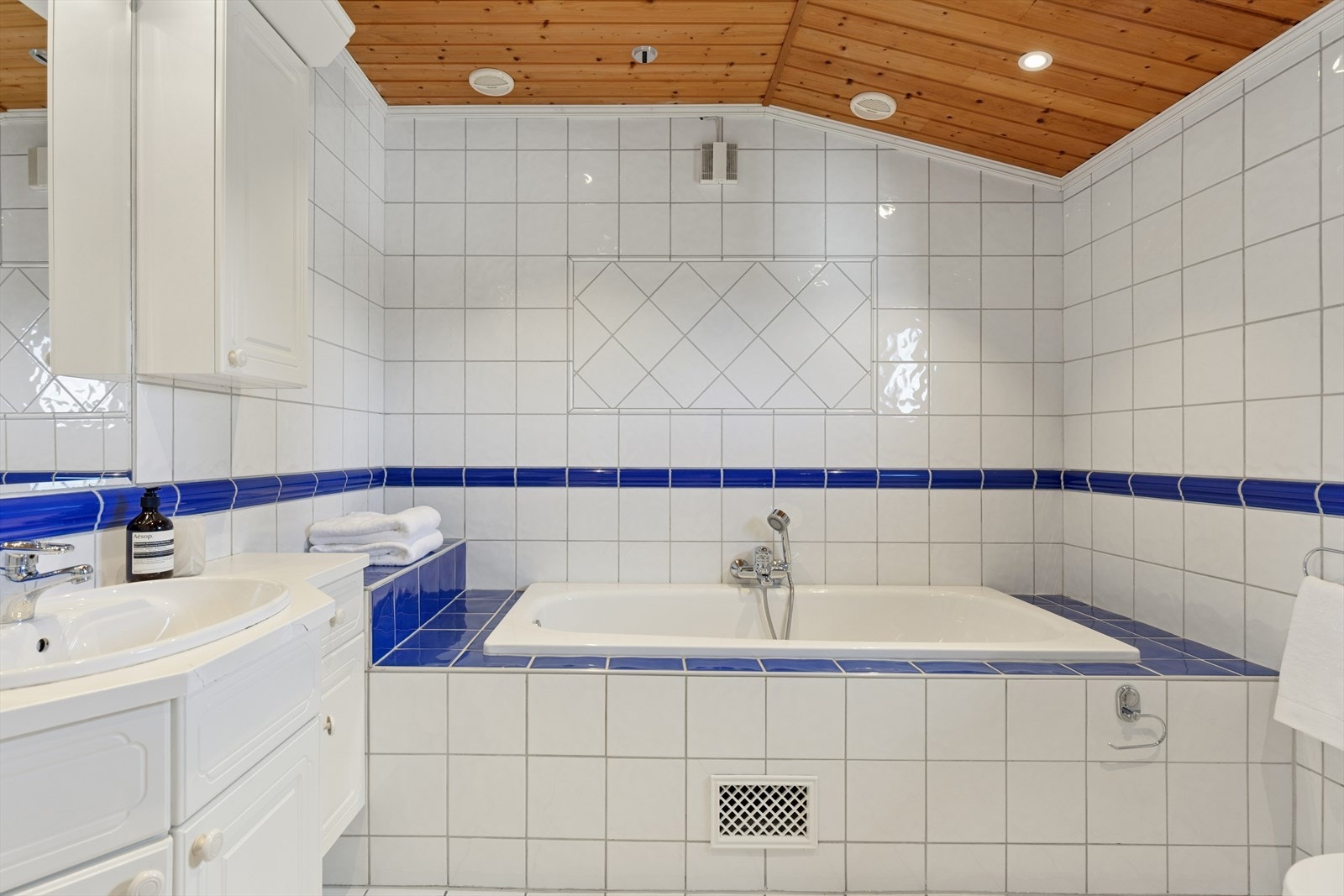 Badet er utstyrt med badekar og har panel i taket. Galleribilde