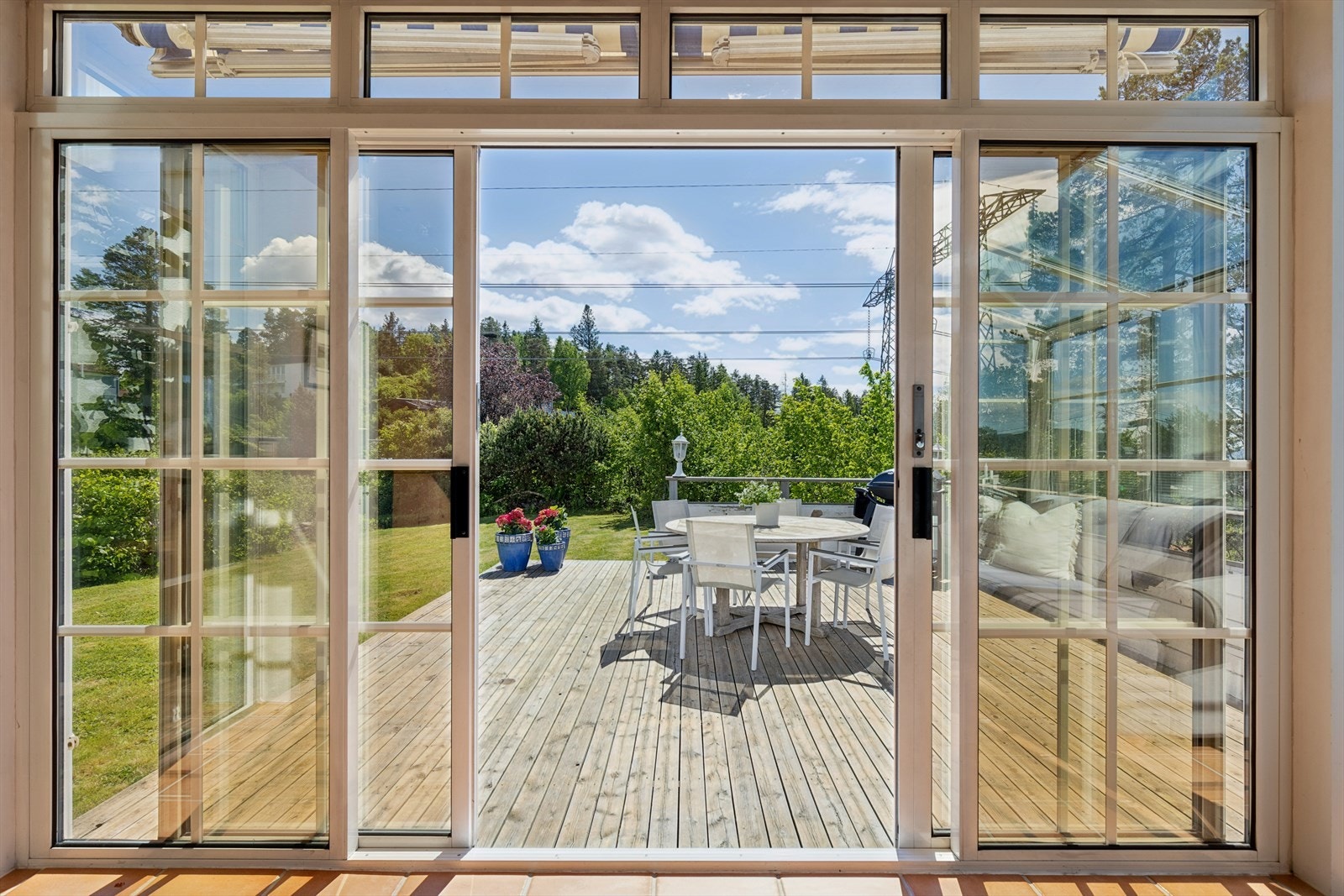 Skyvedører i glass åpner opp mot den store treterrassen og hagen. Galleribilde