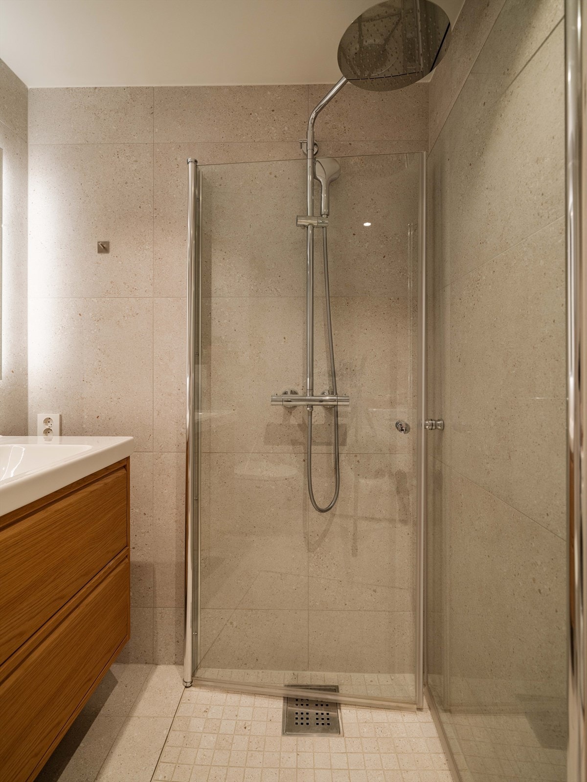 Badet har delikate fliser, romslig dusj med skyvedører og mosaikkfliser på gulvet i dusjsonen, samt regndusj. Galleribilde
